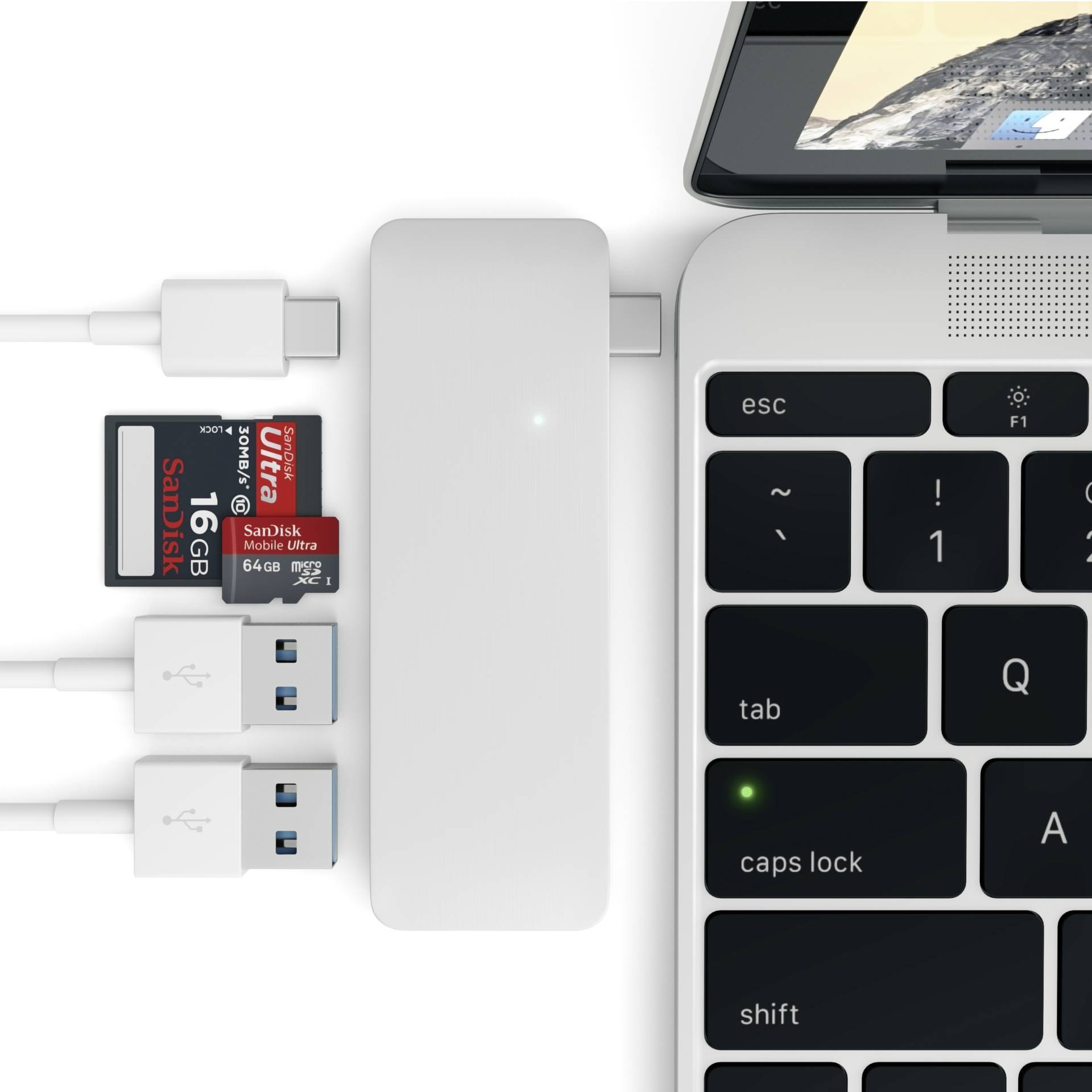 Hub USB-C z podłączonymi urządzeniami: karta SD, dwa pendrive'y, połączone z laptopem. Klawiatura laptopa częściowo widoczna.