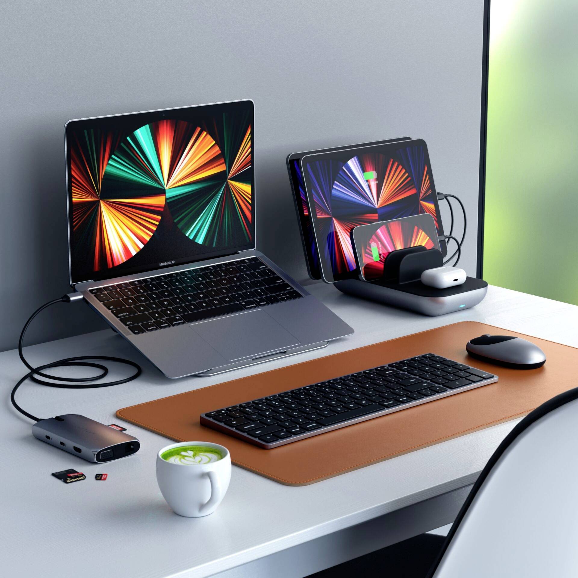 Laptop i tablet z kolorowymi grafikami, bezprzewodowa mysz i klawiatura na biurku. Nowoczesne środowisko pracy.