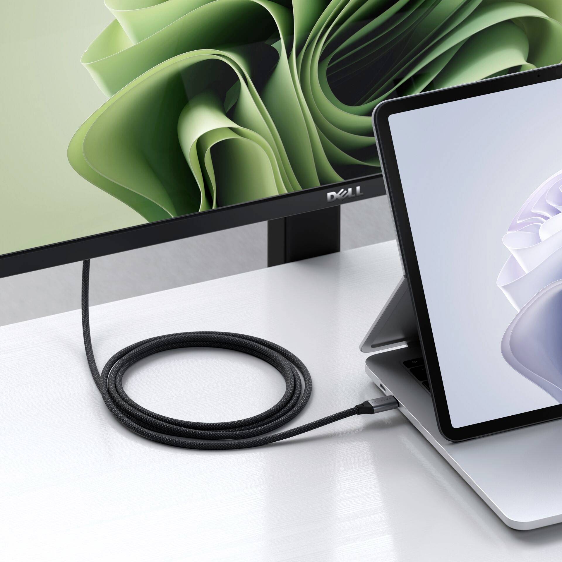 Laptop jest podłączony do monitora. Na monitorze widać abstrakcyjny zielony wzór. Laptop wyświetla podobny obraz.