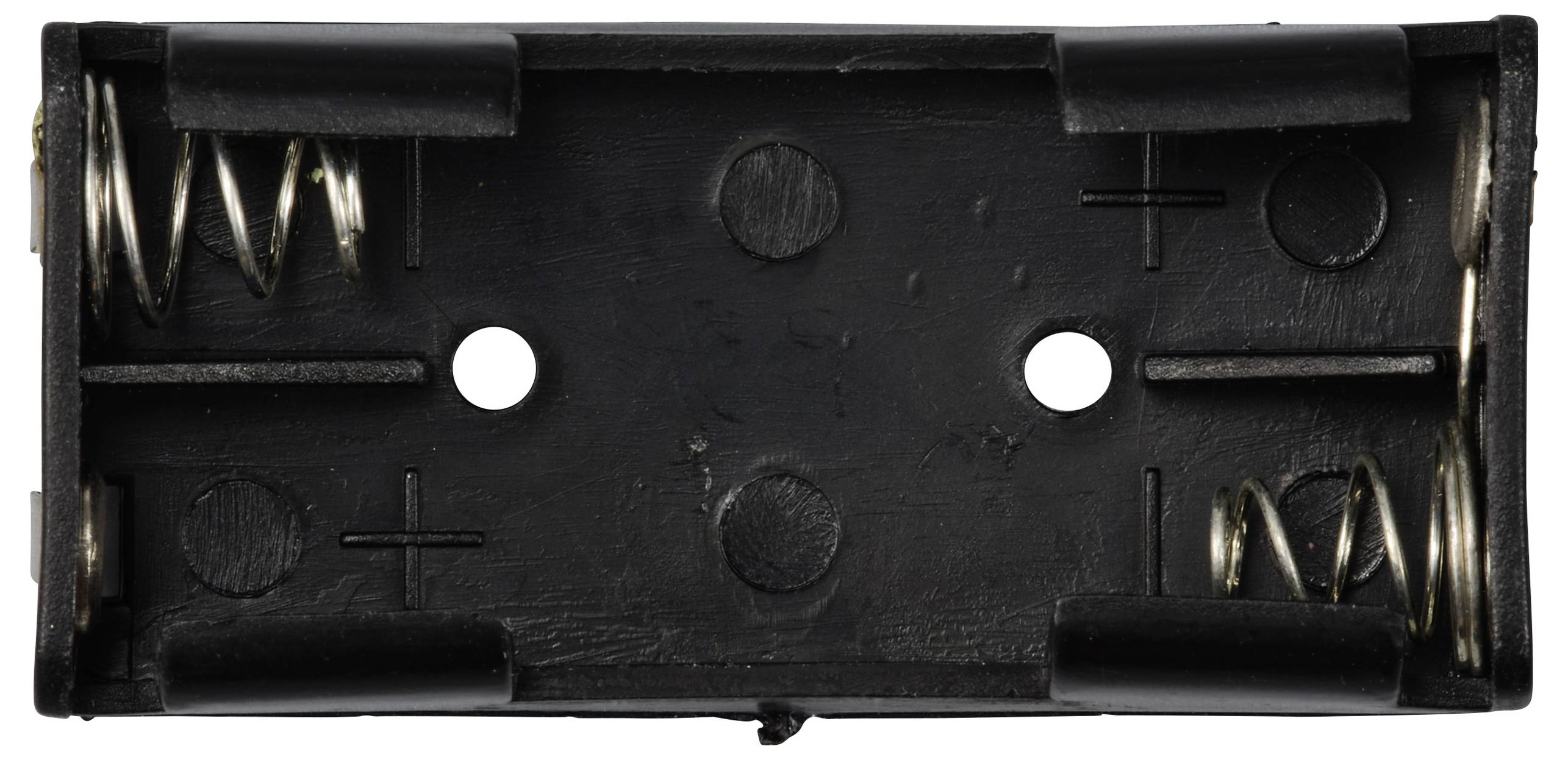 Komora bateryjna na dwie baterie AA, wyposażona w metalowe sprężyny i oznaczenia biegunów.