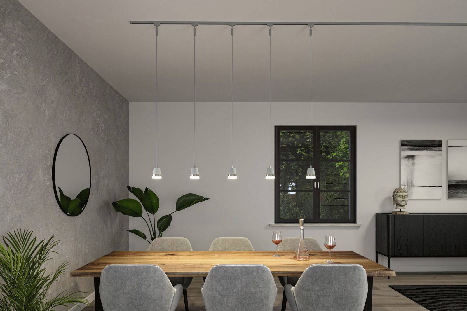 Nowoczesna jadalnia z drewnianym stołem i sześcioma szarymi krzesłami. Nad stołem wiszą pięć lamp wiszących. Na ścianie znajduje się lustro i dzieła sztuki.