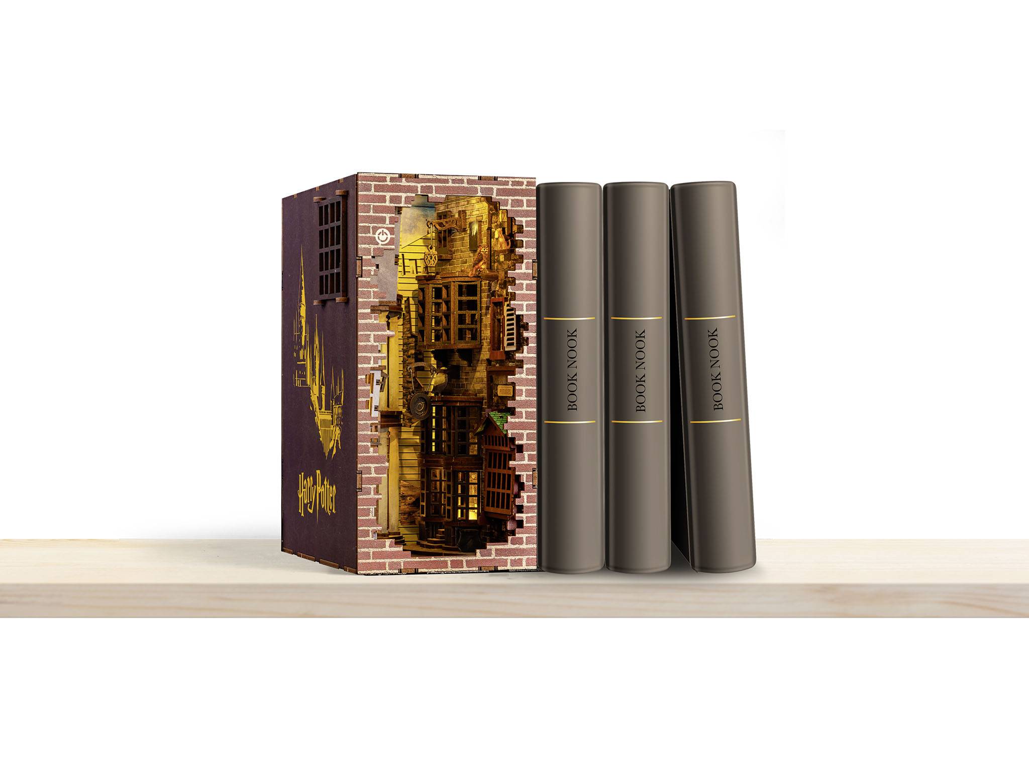 Trzy brązowe książki stoją obok artystycznie wykonanego etui z miejskim motywem, na jasnej drewnianej podłodze.