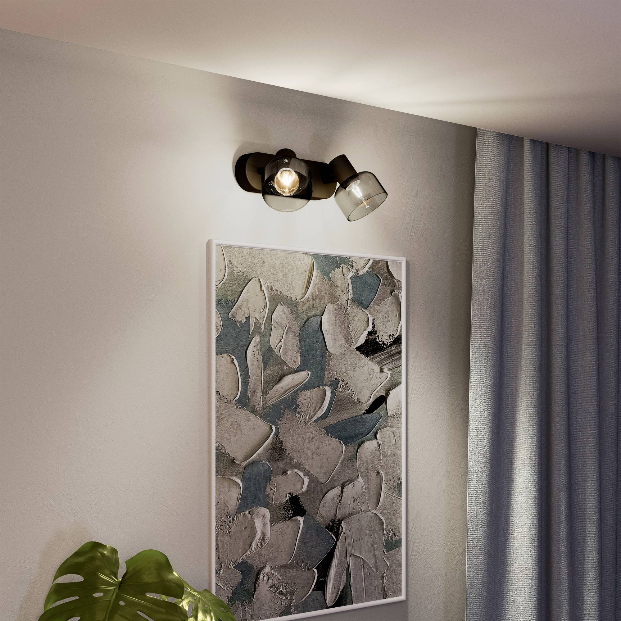 Podświetlone dzieło sztuki z abstrakcyjnymi formami w odcieniach szarości i błękitu na ścianie. Obok roślina doniczkowa i zasłona.