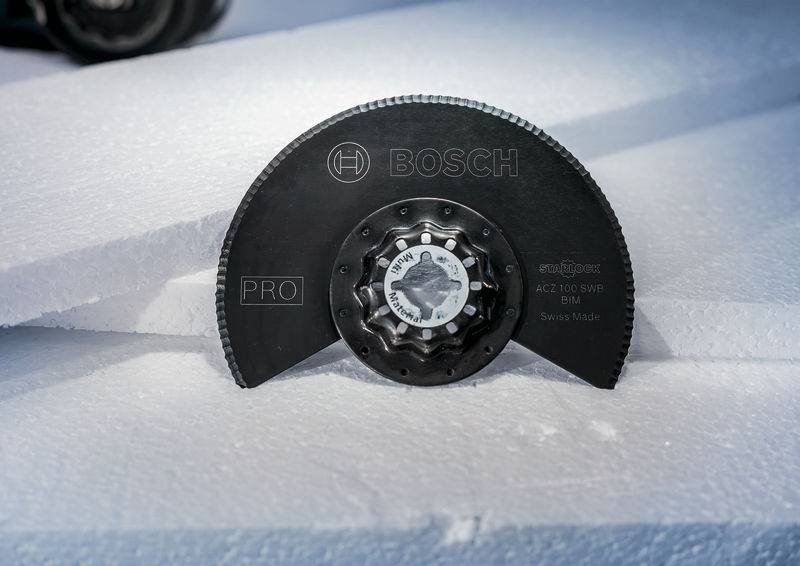 Okrągła, czarna piła tarczowa marki Bosch z metalowymi zębami spoczywa na białej płycie z pianki.