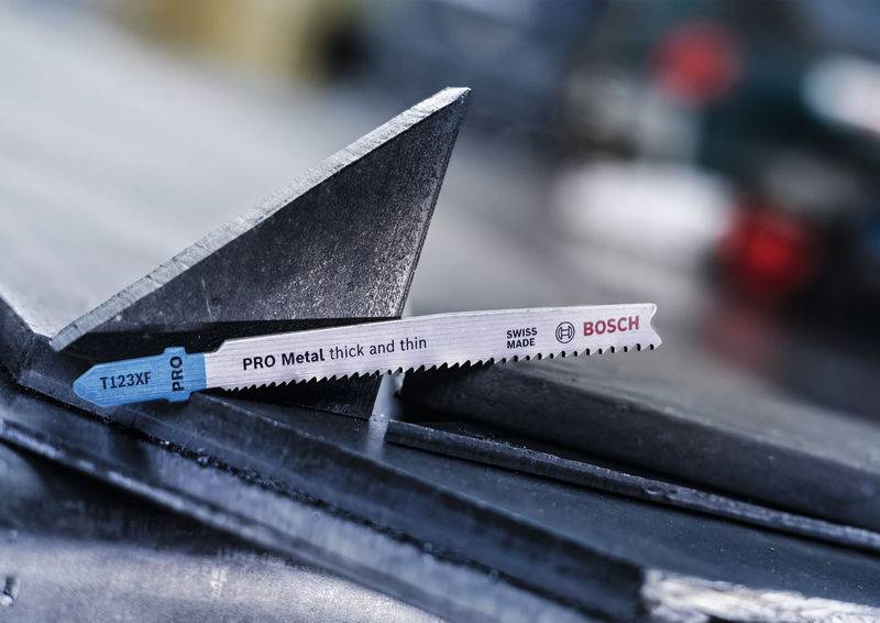 Ostrze piły 'PRO Metal thick and thin' firmy Bosch na powierzchni metalowej. Napis 'SWISS MADE' oraz 'T123XF' na ostrzu.