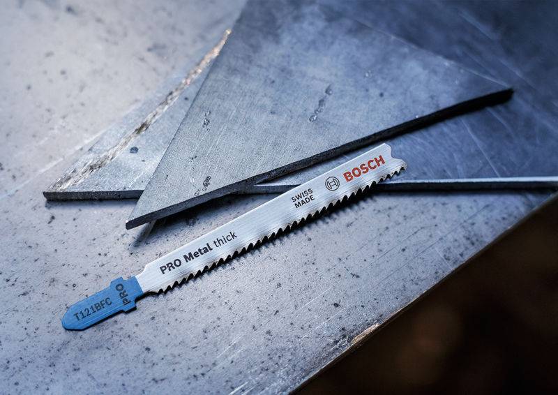 Brzeszczot 'PRO Metal thick' firmy Bosch leży na arkuszu blachy metalowej. Jest odpowiedni do cięcia grubego metalu.