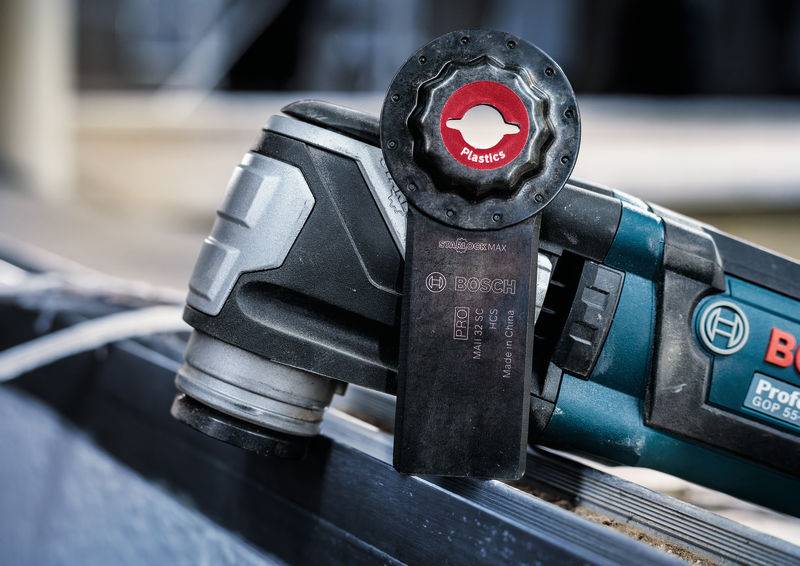 Wielofunkcyjne narzędzie z piłą z tworzywa sztucznego na niebieskim tle, odpowiednie do precyzyjnego cięcia różnych materiałów.