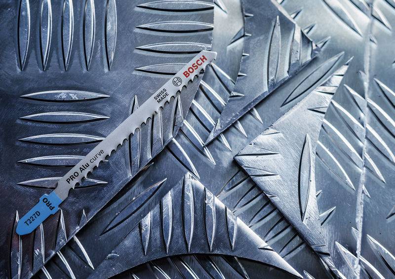 Ostrze piły do metalu 'PRO Alu curve T127D' firmy Bosch leży na szlifowanej powierzchni metalowej z rowkowanym wzorem.