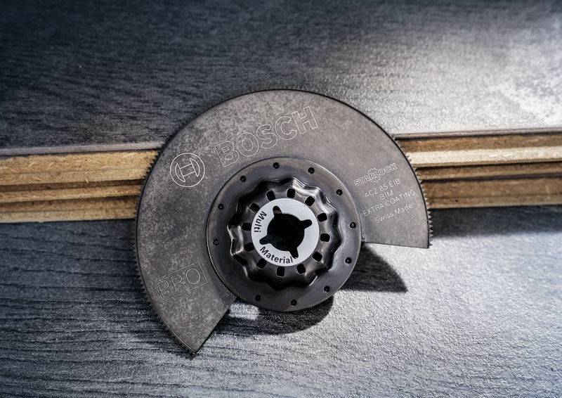 Okrągła piła tarczowa z metalowymi zębami leży na drewnianej powierzchni. Na tarczy widoczne jest logo producenta.