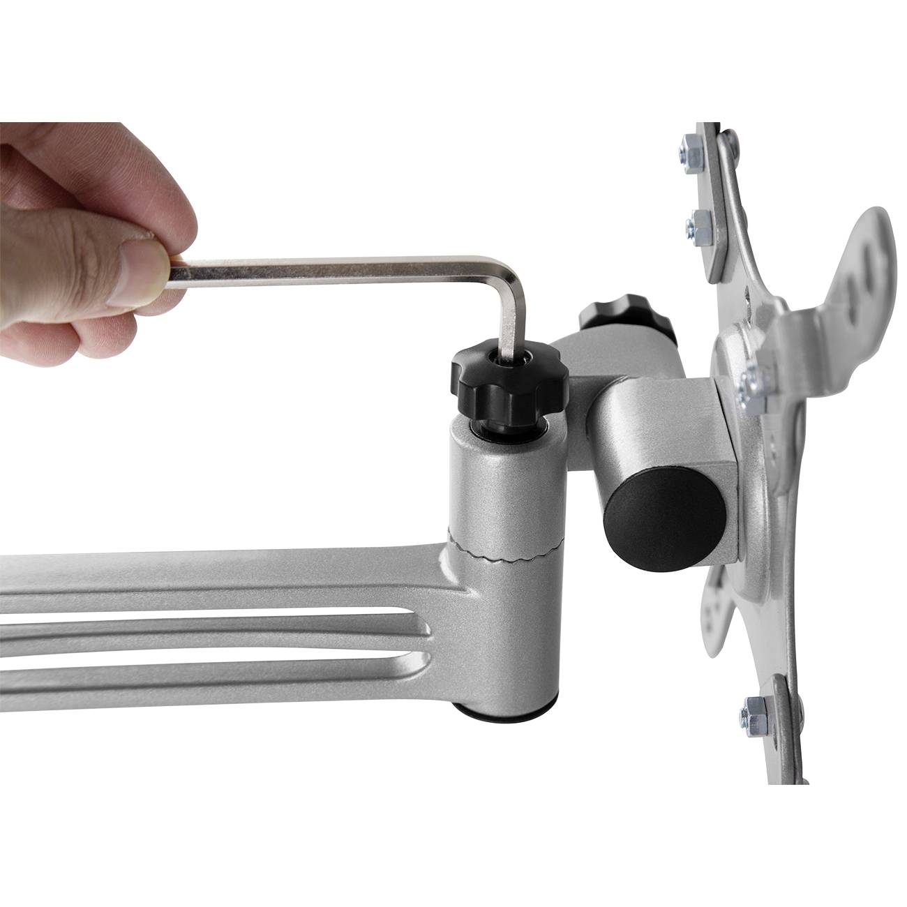 Ręka dokręca wkręt kluczem imbusowym na srebrnym ramieniu obrotowym zamocowanym w uchwycie monitora.