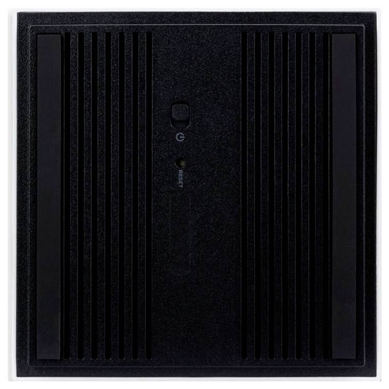 Czarny głośnik z pionowymi szczelinami, centralnym przyciskiem i małym logo powyżej przycisku.