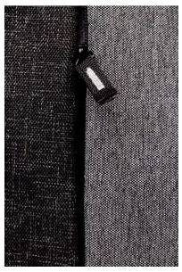 Zbliżenie ciemnej struktury tkaniny z małą etykietą przymocowaną do szwu.