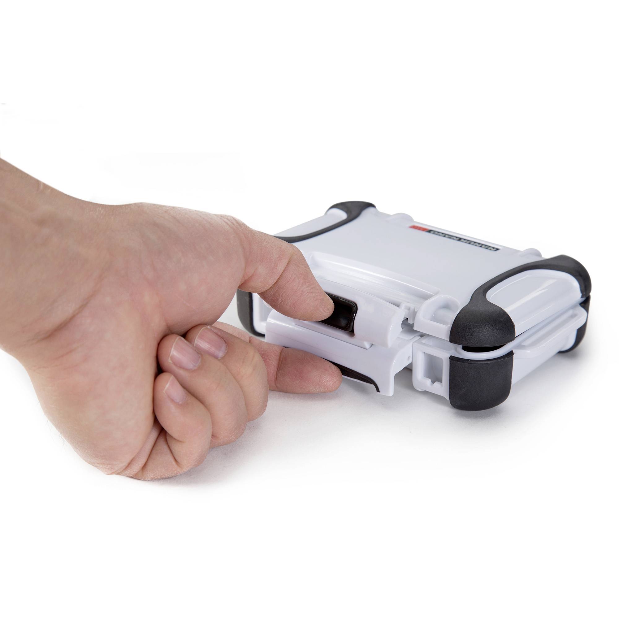 Dłoń naciska przycisk na małym, białym urządzeniu z czarnymi narożnikami.