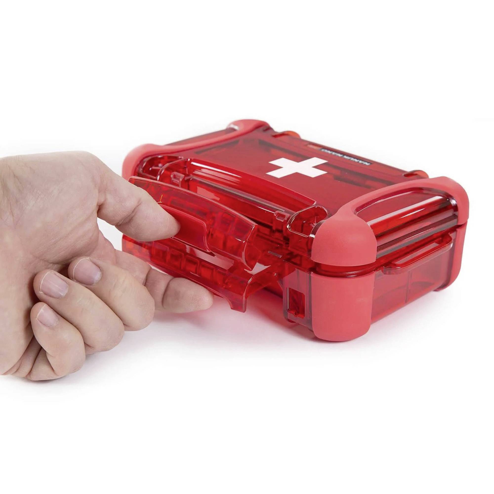 Ręka otwiera czerwony apteczkę pierwszej pomocy z białym krzyżem na pokrywie.