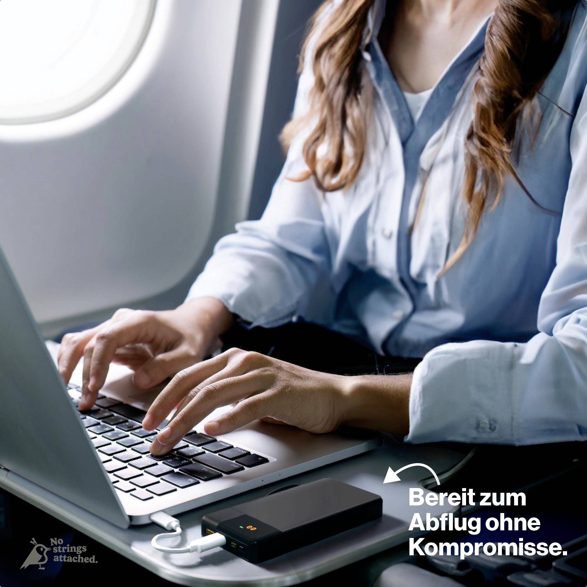 Osoba pisze na laptopie w samolocie. Smartfon ładuje się przez powerbank. Tekst: 'Gotowy do lotu bez kompromisów.'