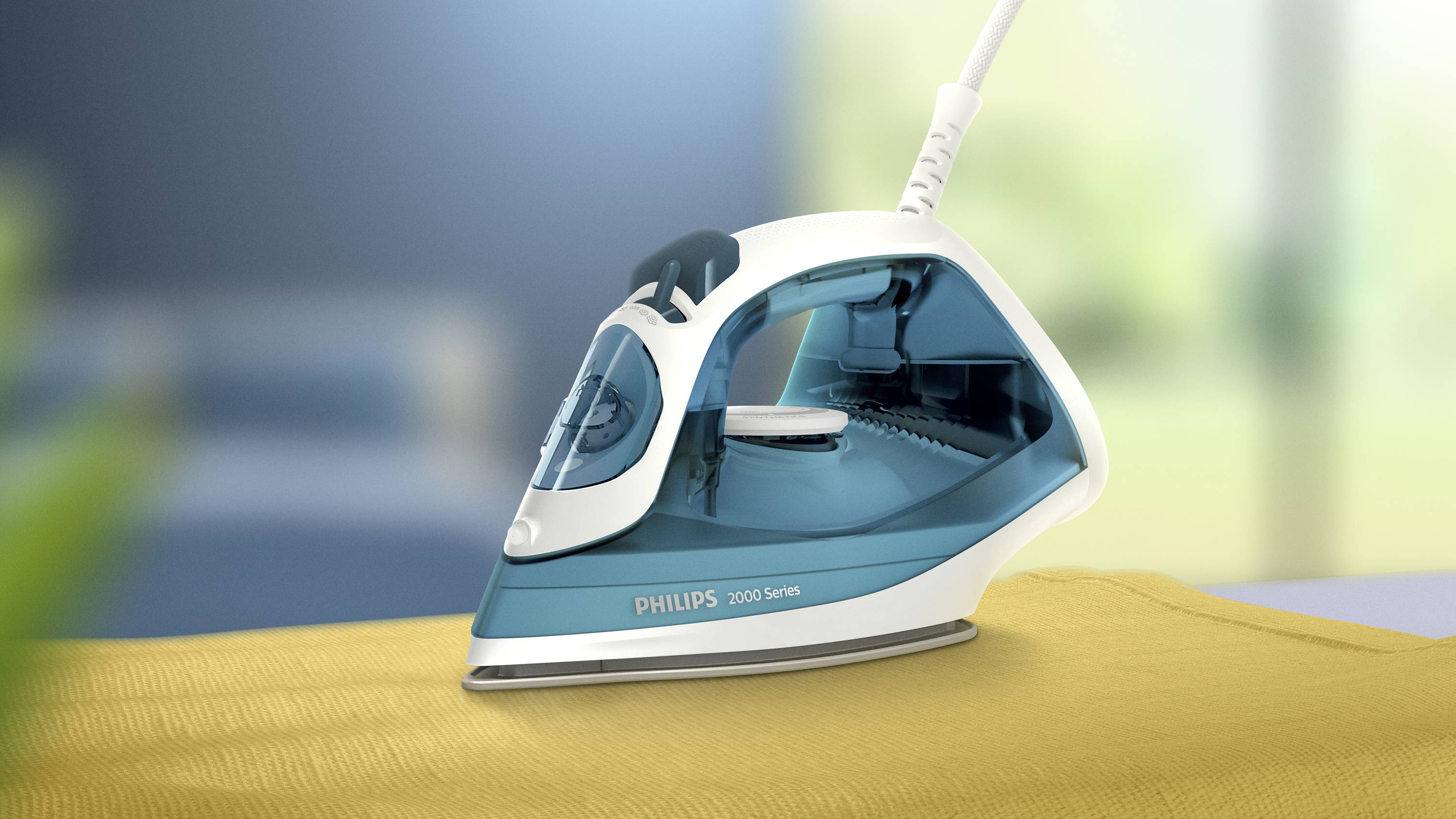 Żelazko parowe marki Philips z serii 2000 stoi na żółtej tkaninie. Tło jest rozmyte.