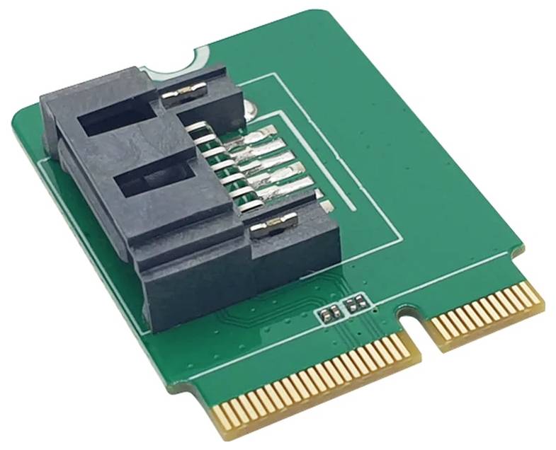 Zielona płytka elektroniczna z czarnym elementem i złotymi stykami, prawdopodobnie karta rozszerzeń komputerowych.