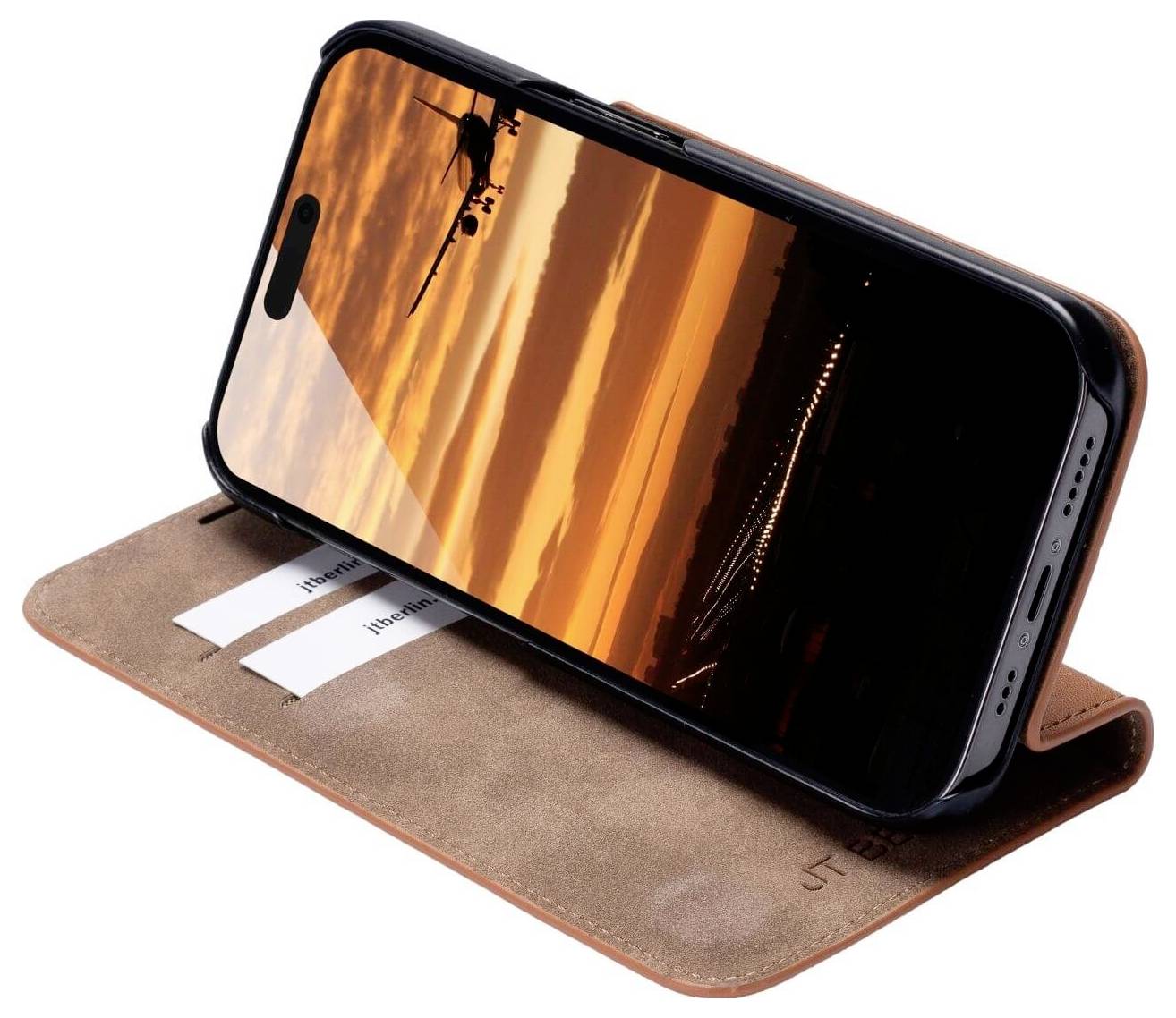 Smartfon w brązowym etui wyświetla zdjęcie samolotu na tle pomarańczowego zachodu słońca.