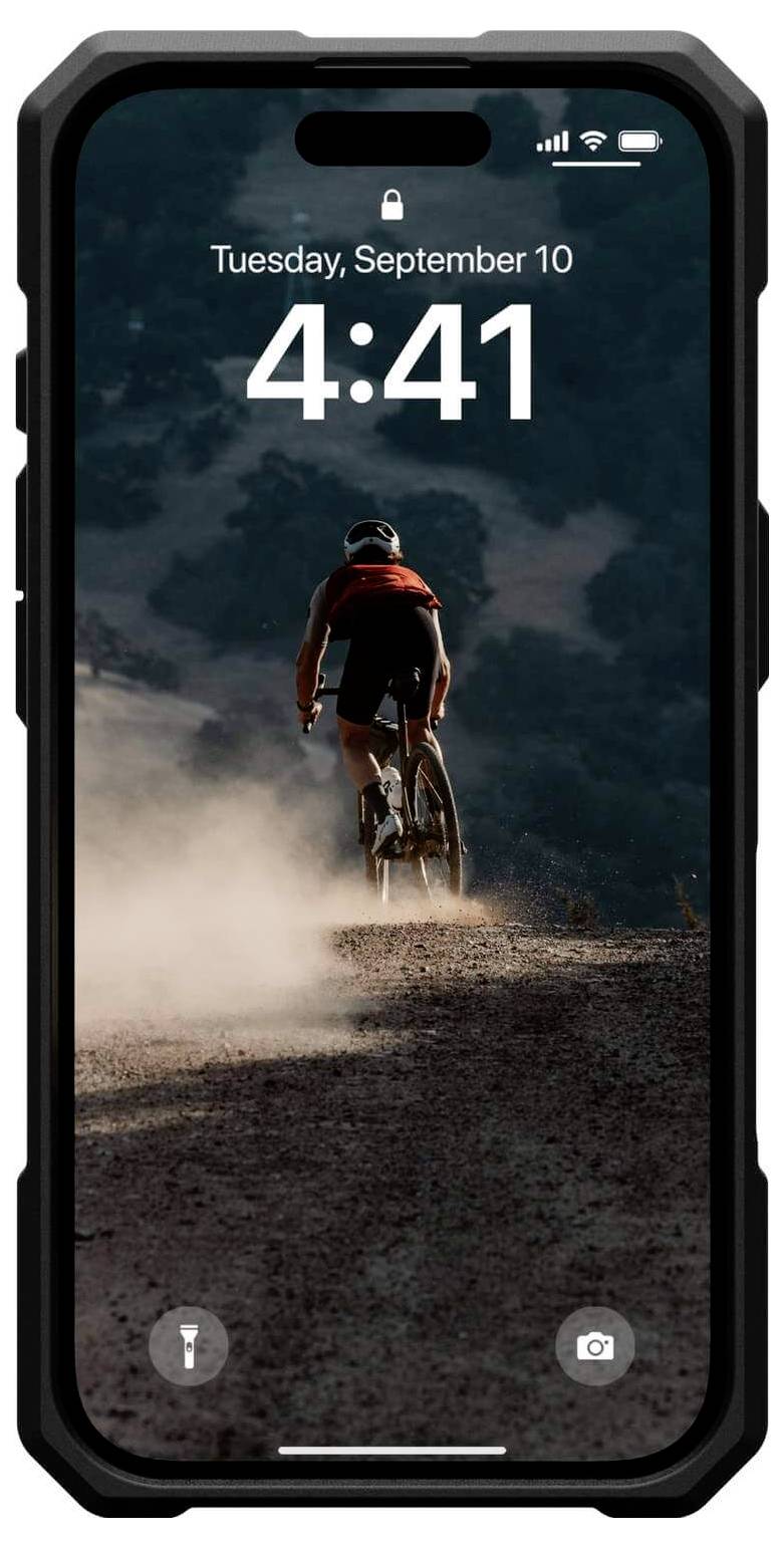 Rowerzysta na zakurzonym szlaku, w tle pofałdowany krajobraz. Na smartfonie widać godzinę 4:41.