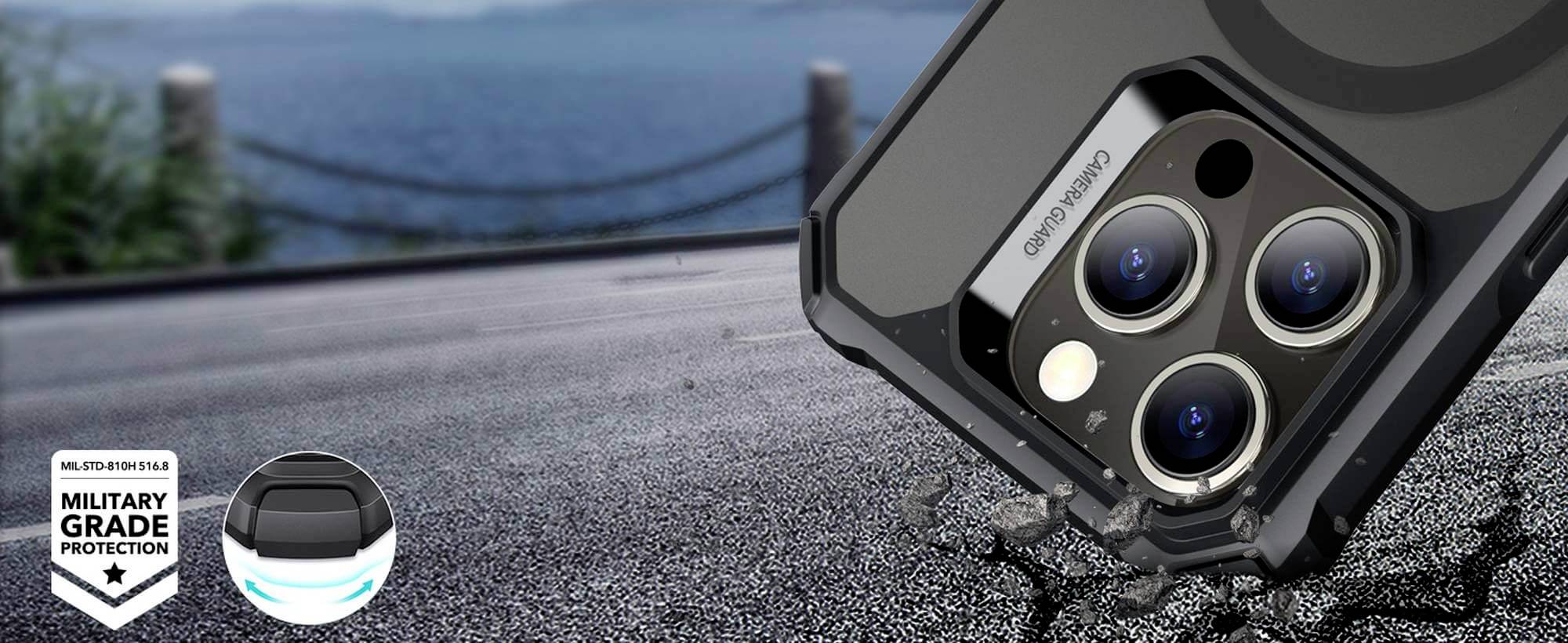 Zbliżenie smartfona w wytrzymałej obudowie na asfalcie, z fokusem na aparat. Napis: 'OCHRONA NA POZIOMIE WOJSKOWYM'. W tle widać morze.