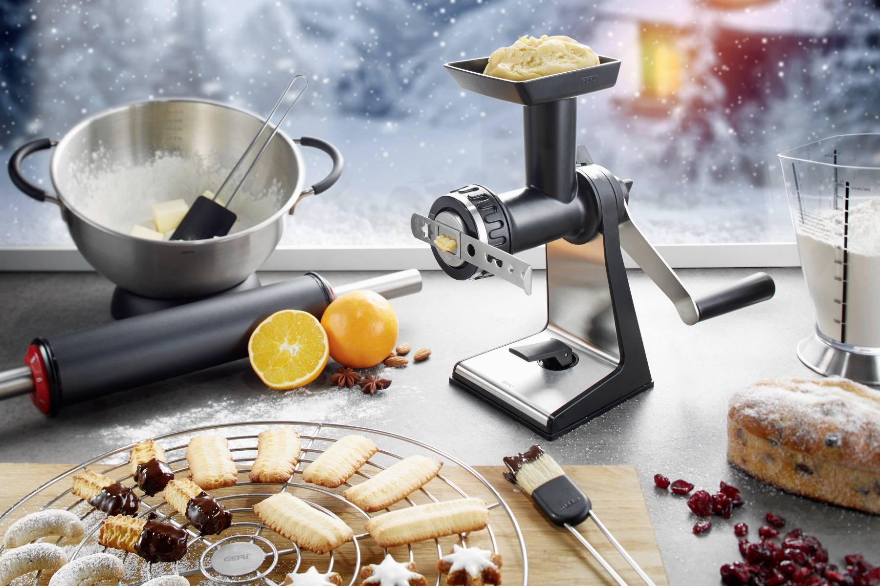 Kuchnia z ciasteczkami, ciastem i składnikami. Na pierwszym planie wilk do mięsa z ciastem, po lewej miska i wałek. Tło w zimowym stylu.