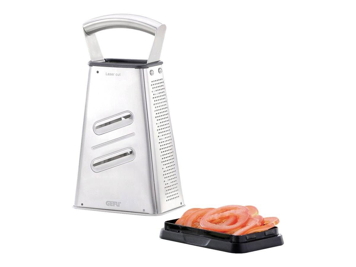 Tarka ze stali nierdzewnej obok pokrojonych pomidorów na małej czarnej płytce.