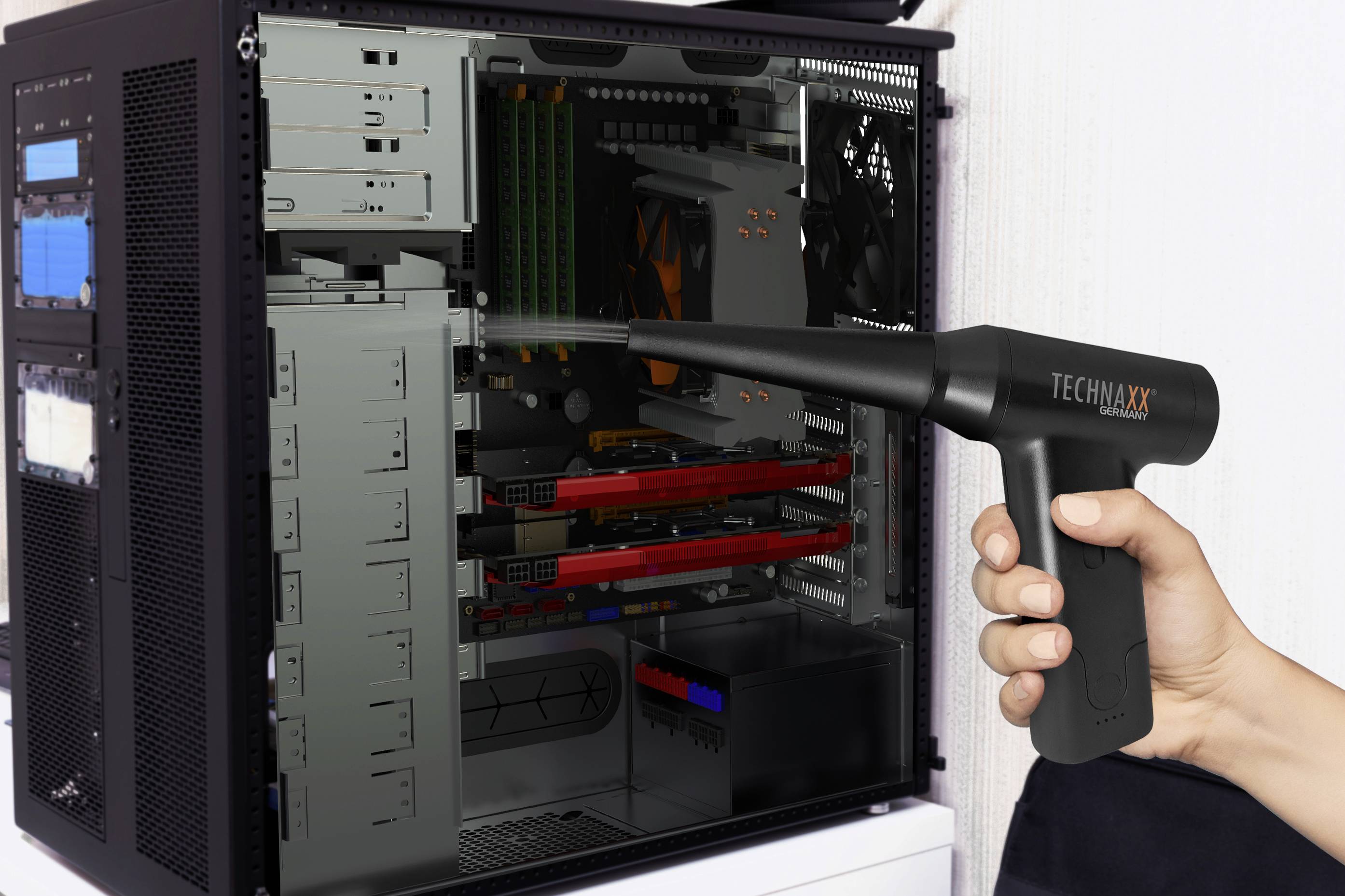 Osoba czyści wnętrze otwartej obudowy komputera dmuchawą elektryczną, aby usunąć kurz.