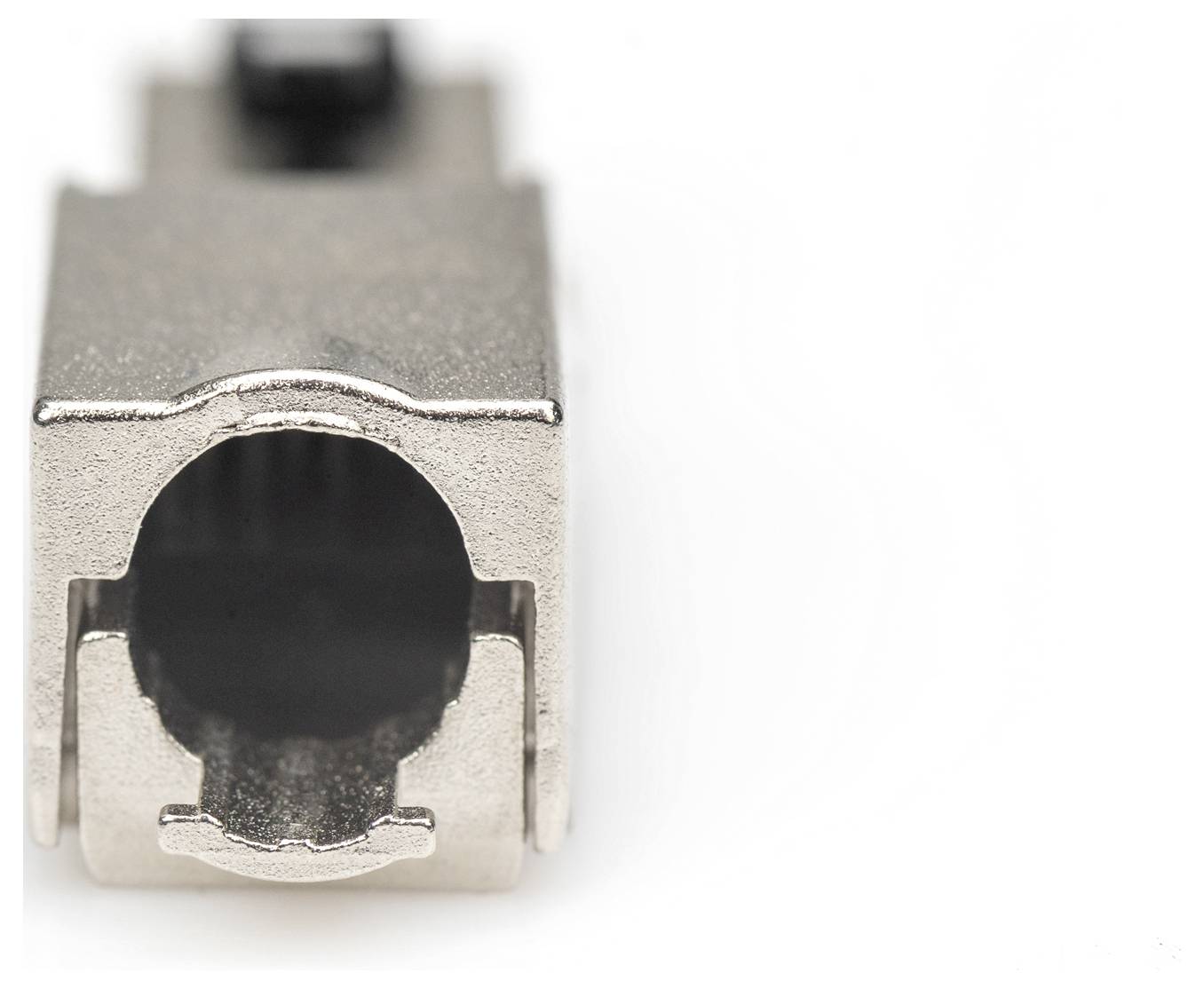 Zbliżenie wtyczki metalowej używanej do połączeń elektronicznych. Ostrość obrazu skupiona jest na otwartym gnieździe.