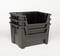 Trzy czarne plastikowe skrzynki ułożone jedna na drugiej na białym tle.