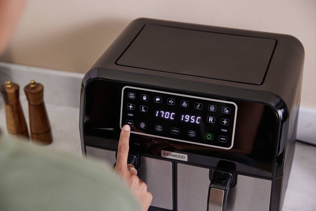 Osoba używa wyświetlacza podwójnej frytownicy. Przyciski pokazują ustawienia temperatury: po lewej 170°C, po prawej 195°C.