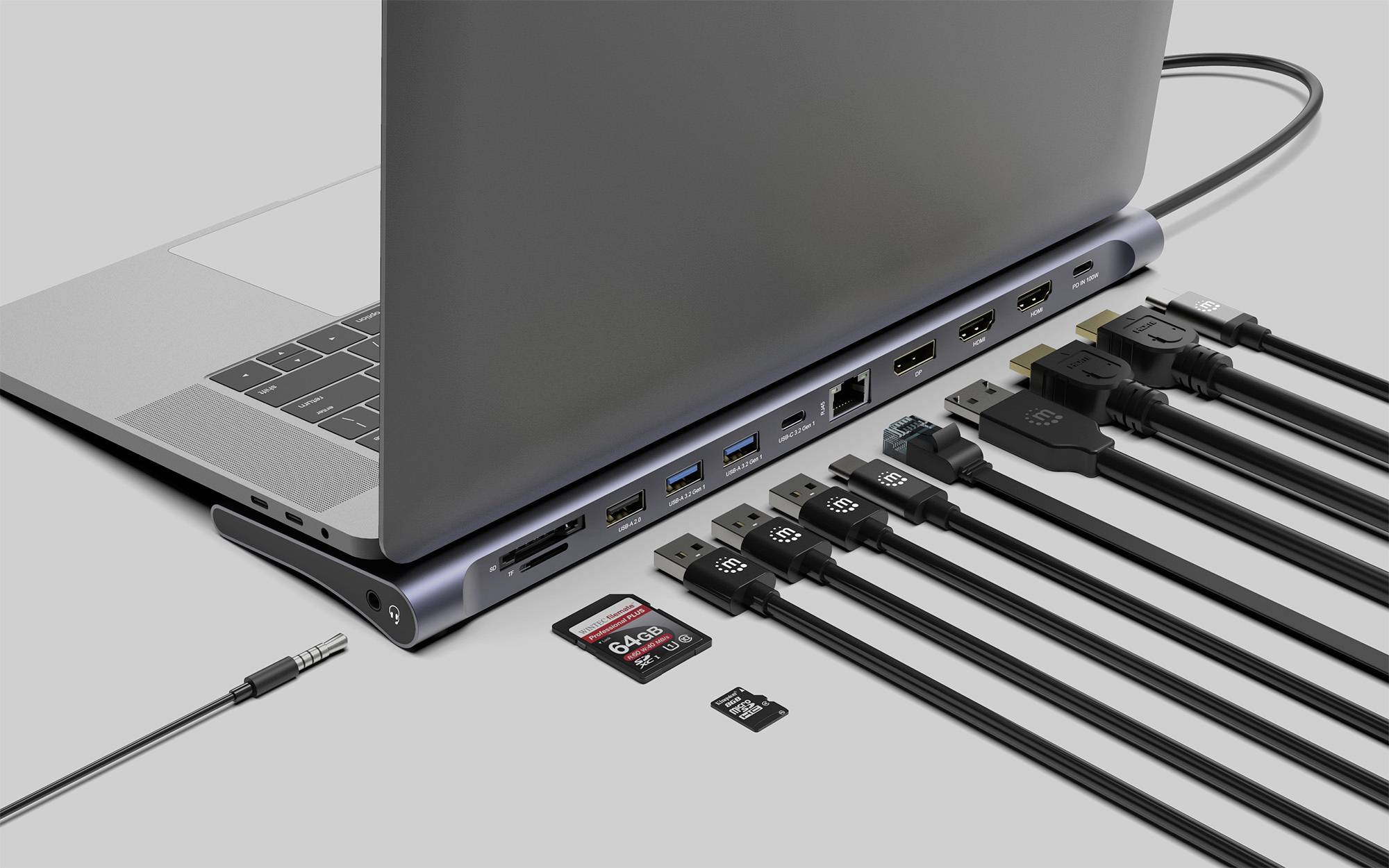 Laptop jest podłączony do stacji dokującej z wieloma portami. Do stacji podłączonych jest kilka kabli i kart pamięci.