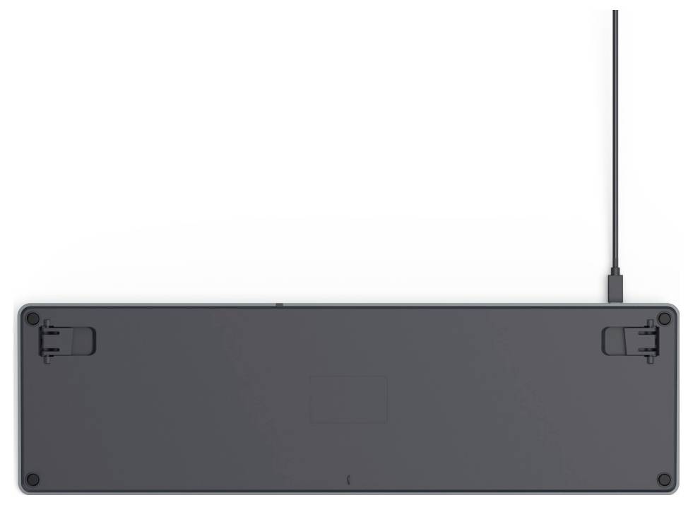 Tylna strona klawiatury z rozłożonymi nóżkami i podłączonym kablem USB, leżącej na białej powierzchni.