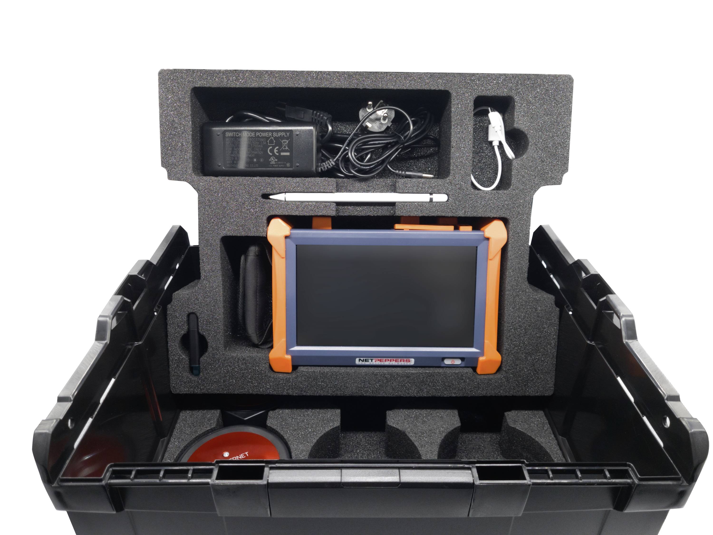 Otwarta czarna obudowa z urządzeniem diagnostycznym, zasilaczem, rysikiem, przewodem i ekranem osadzonymi w wyściółce piankowej.