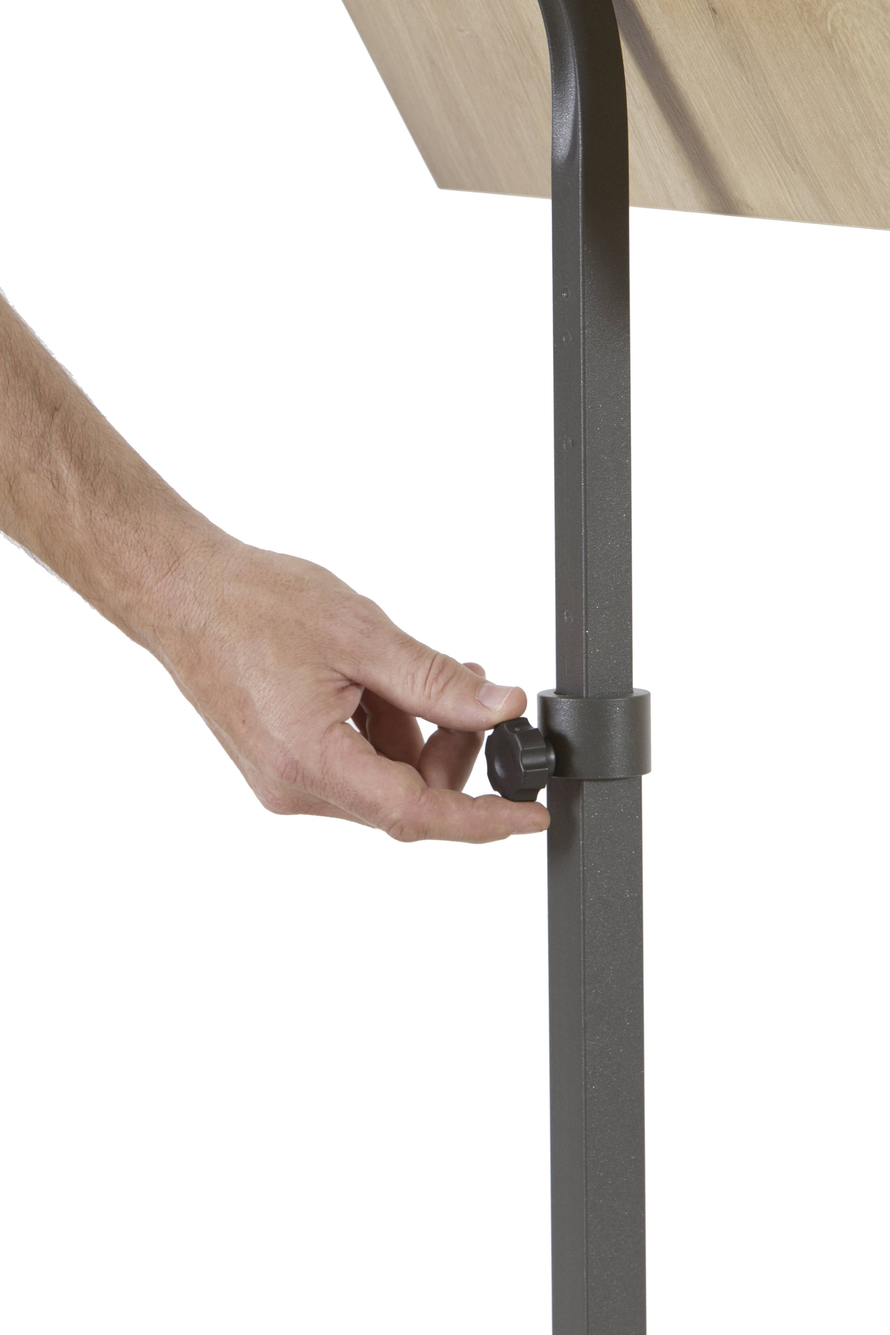 Ręka reguluje czarną dźwignię przy metalowej nodze stołu. Stół posiada drewnianą płytę.