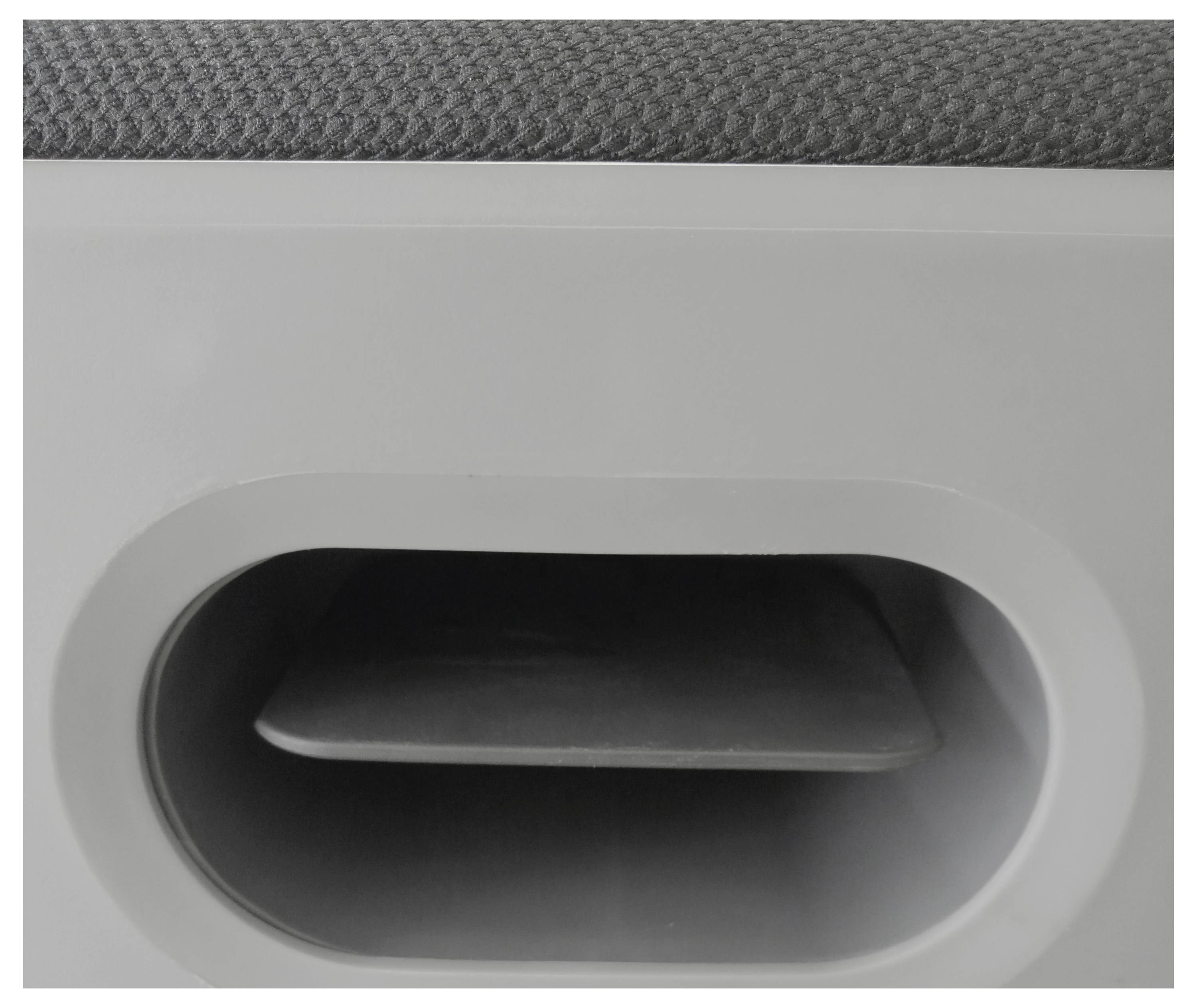 Fragment szarego mebla z owalnym uchwytem lub otworem, ukazujący teksturę i kształt.