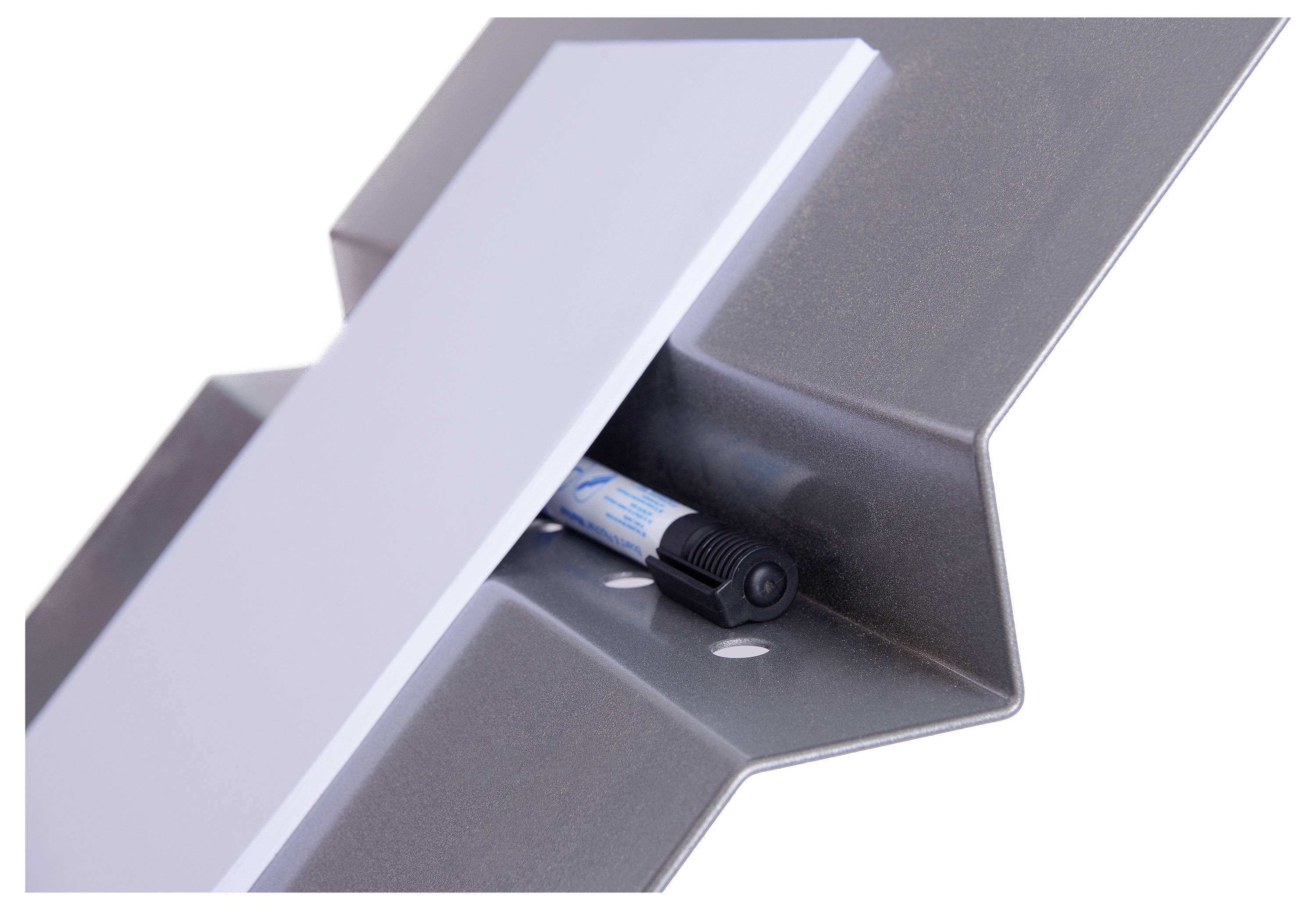 Marker do tablicy leży w uchwycie nowoczesnego, srebrnego stojaka do tablic.