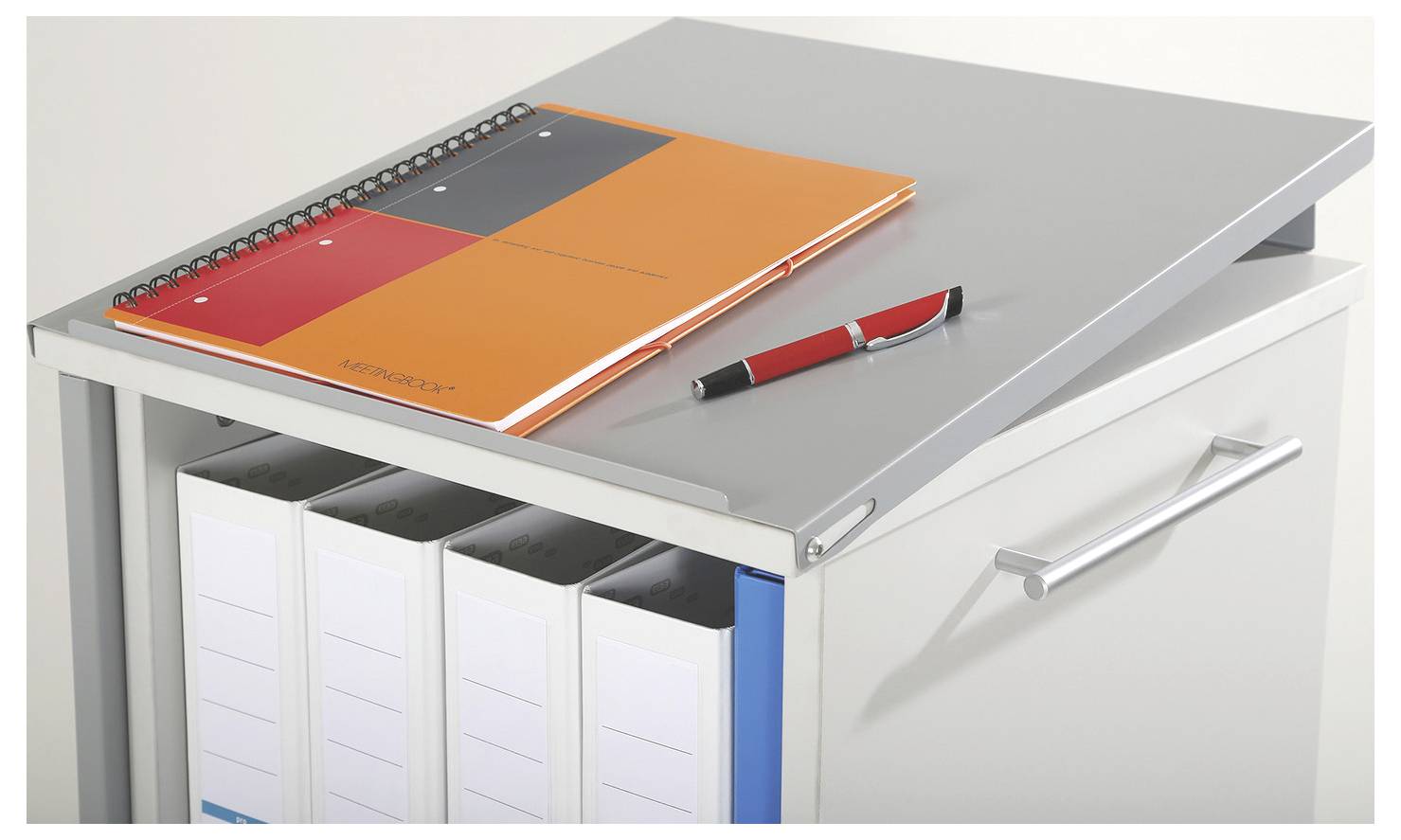 Stojak na dokumenty z kilkoma segregatorami, na którym leży rozłożony notes i długopis.