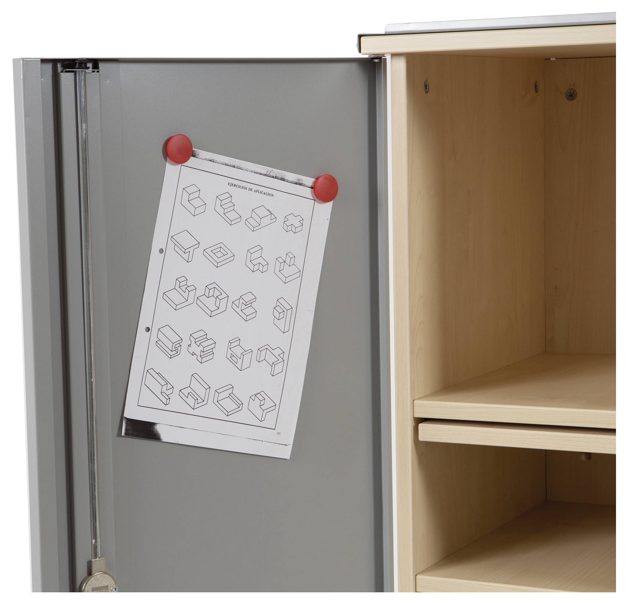 Szara metalowa szafka z otwartą drewnianą półką obok; kartka papieru z geometrycznymi instrukcjami składania wisi na drzwiach szafki.