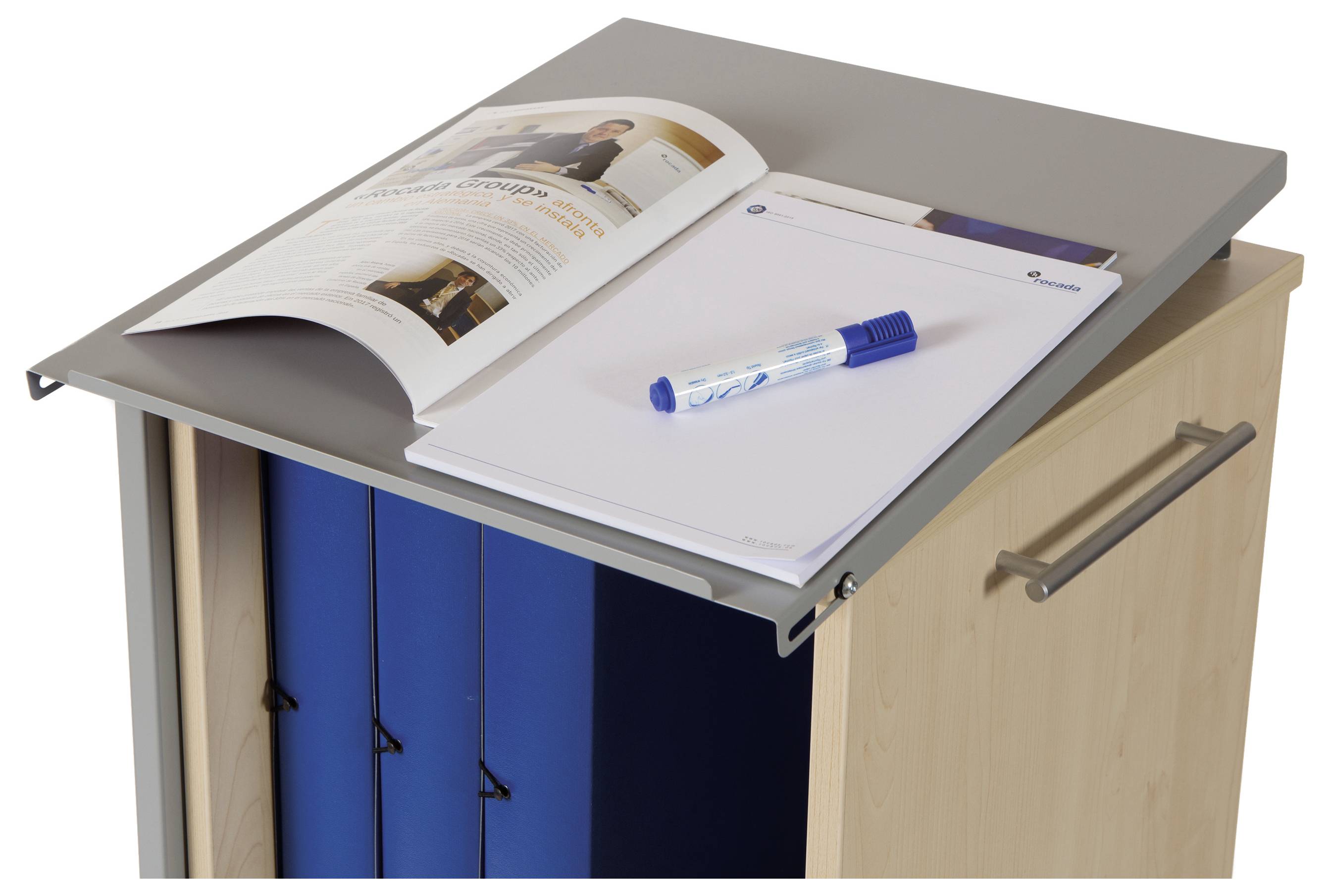 Gazeta i przybory do pisania na szafce na dokumenty z otwartymi segregatorami.