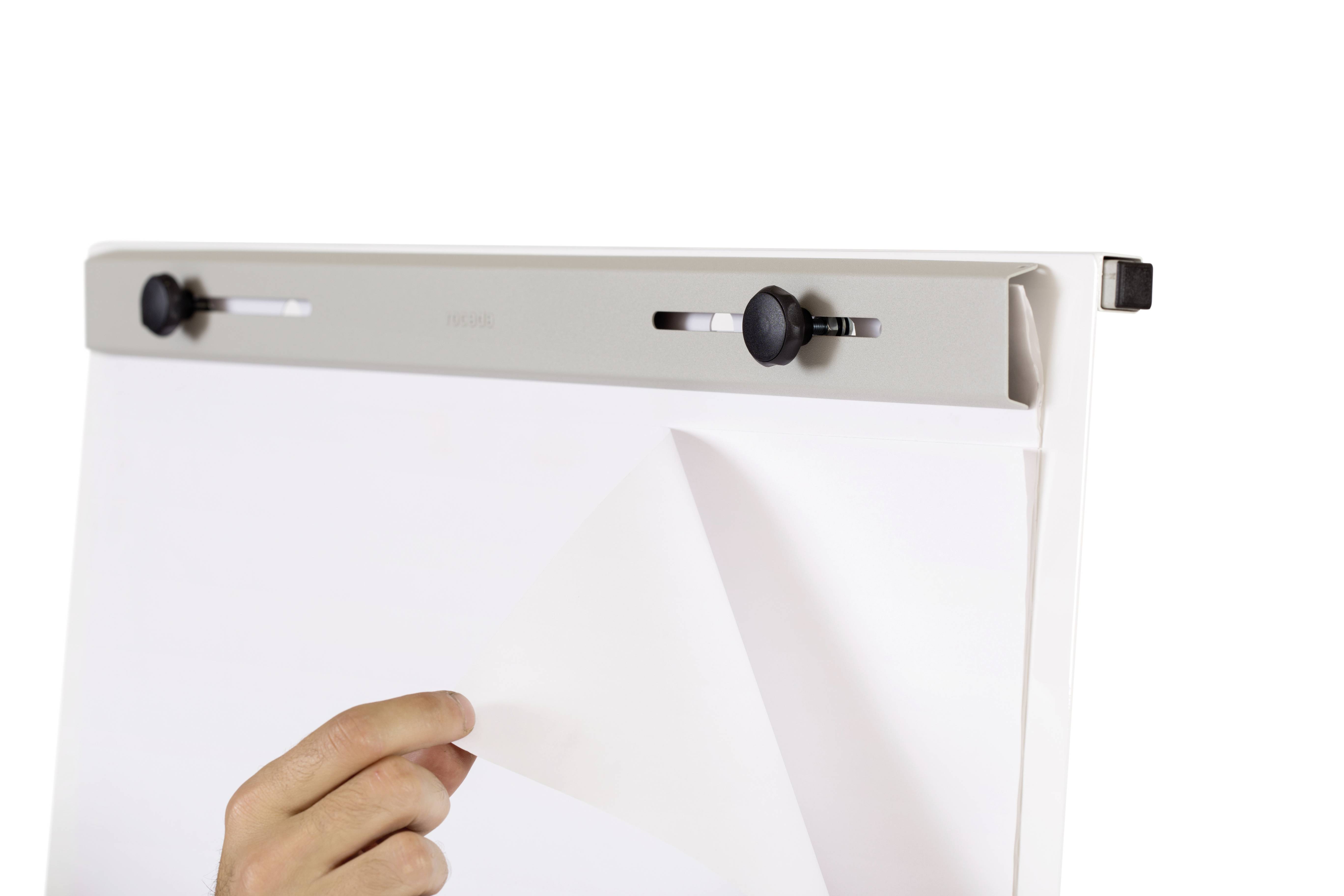Ręka odrywa arkusz papieru z bloku na tablicy flipchart. Tablica ma metalowy uchwyt u góry.