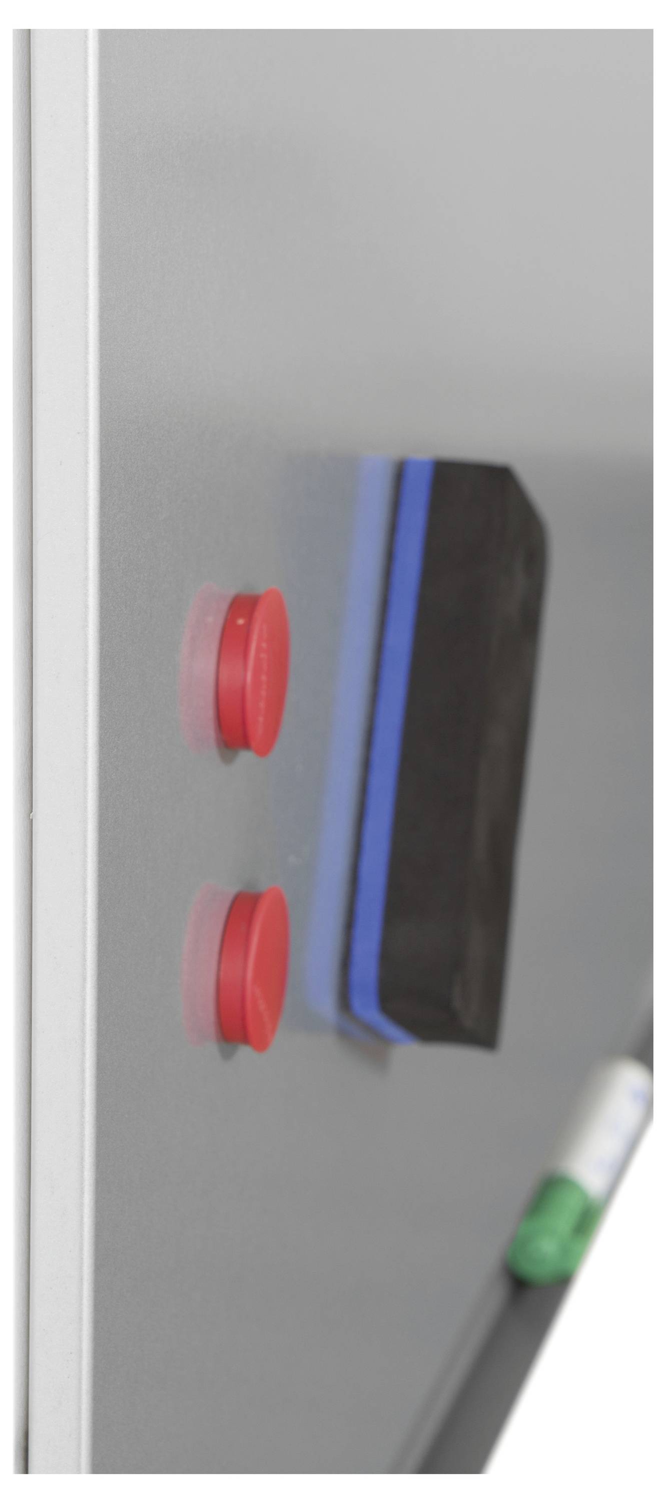 Widok z boku tablicy białej z dwoma czerwonymi magnesami i czarną gąbką. Zielony marker jest widoczny u dołu po prawej stronie.