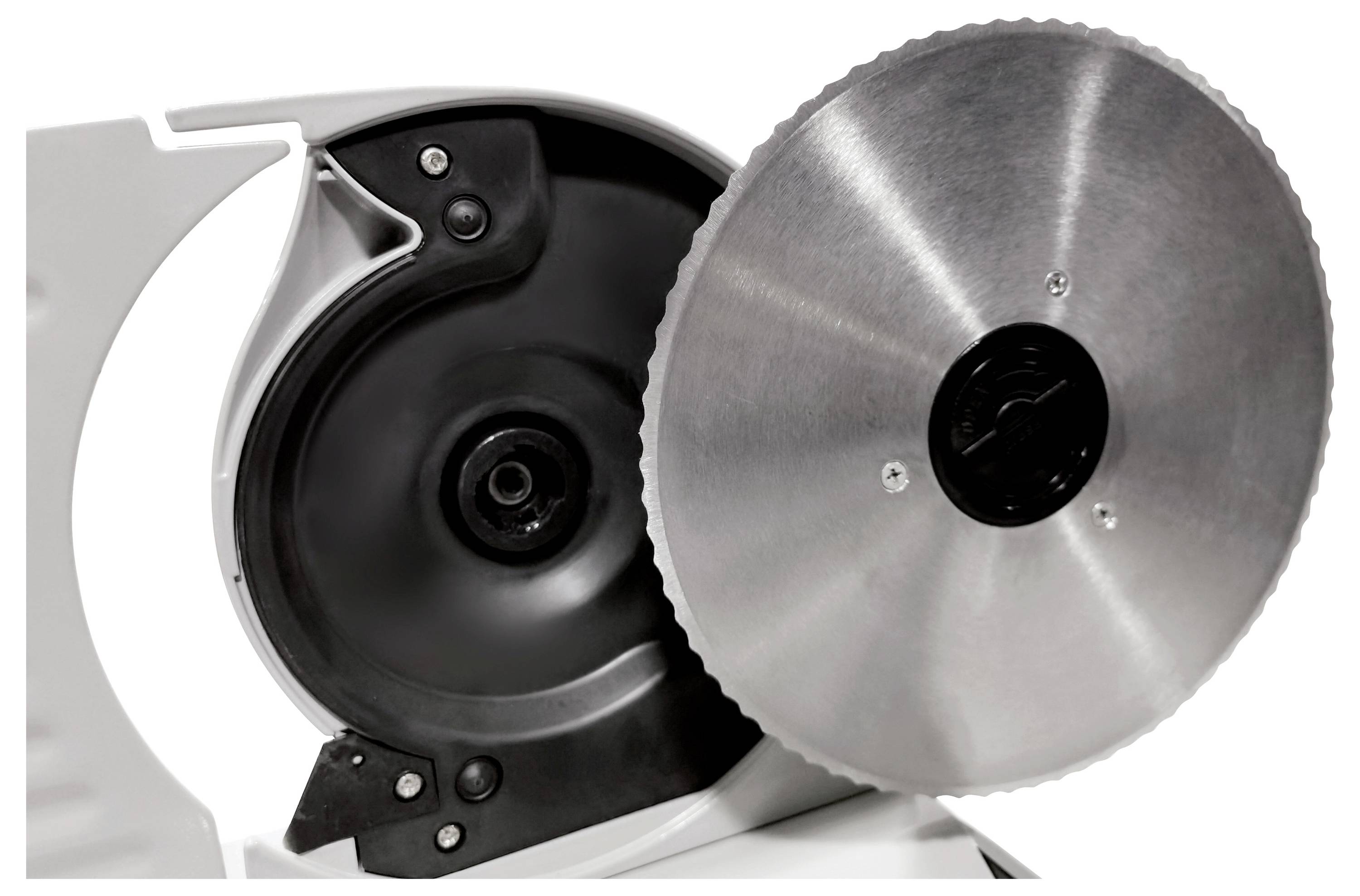 Metalowa tarcza krajarki do wędlin jest częściowo widoczna. Widać na niej ostrze oraz zabezpieczenia.