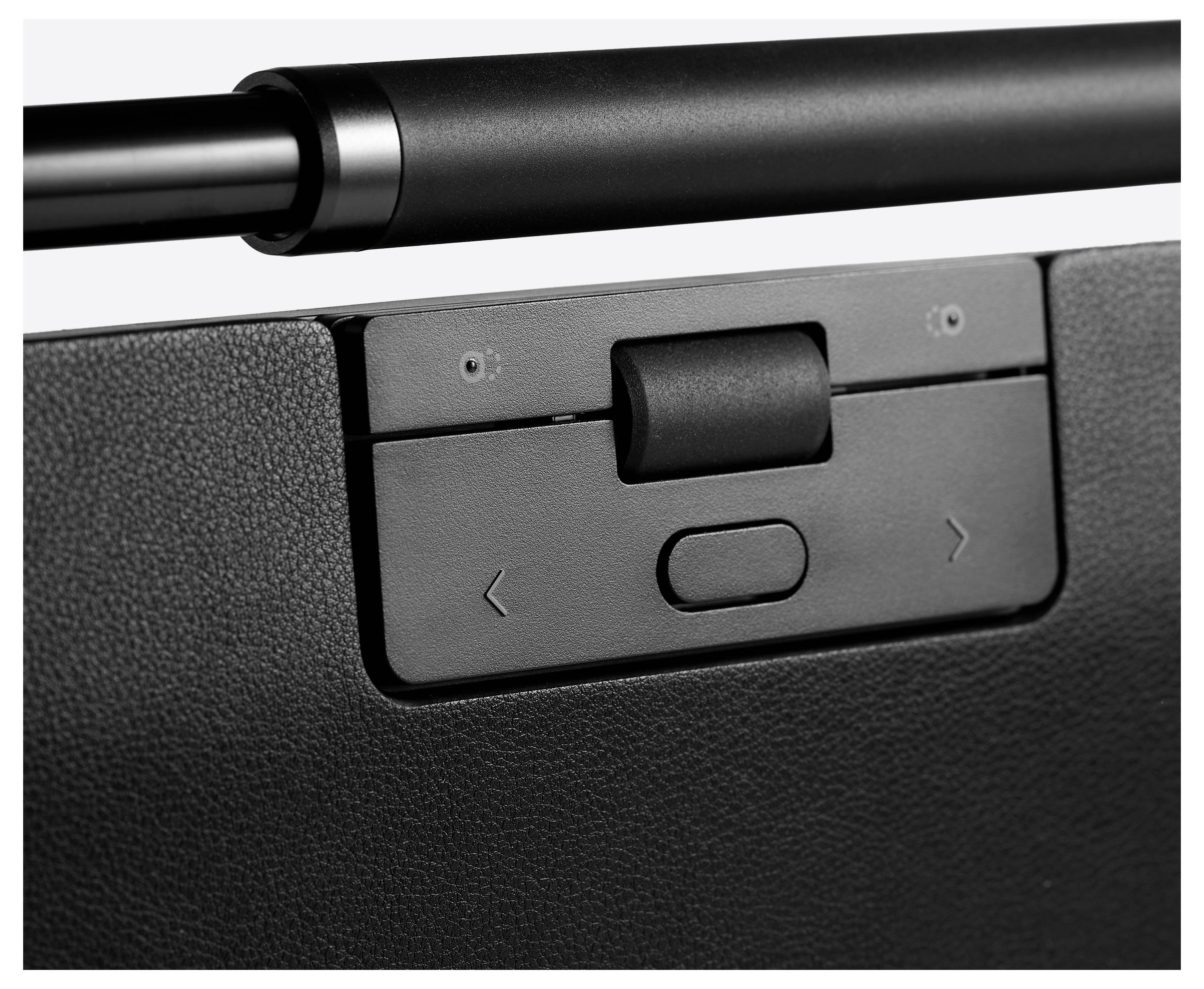 Zbliżenie czarnego urządzenia elektronicznego z obrotowym przełącznikiem pośrodku oraz strzałkami po lewej i prawej stronie do nawigacji.