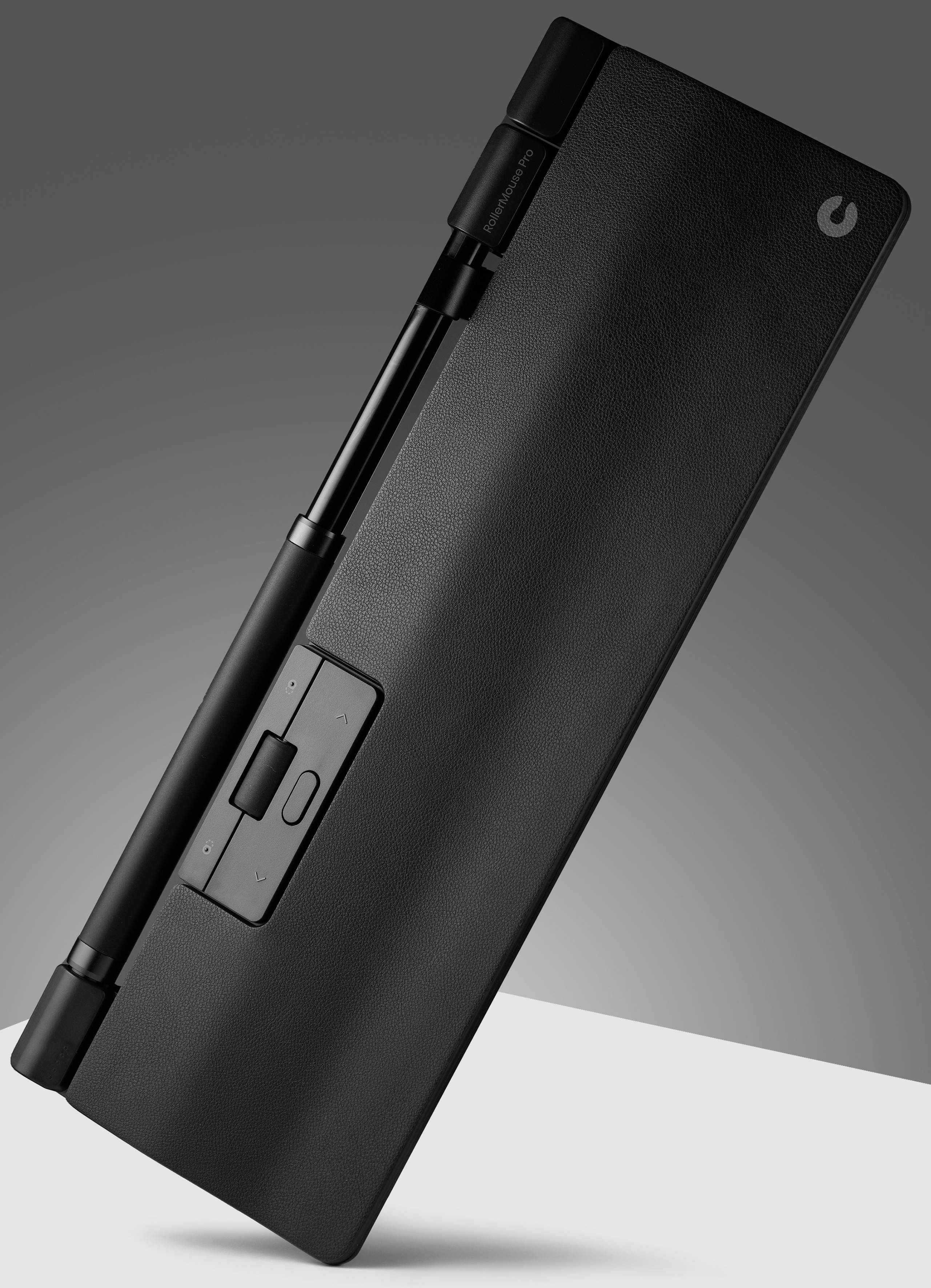 Czarny, prostokątny głośnik Bluetooth z uchwytem i przyciskami sterującymi, umieszczony na skos na szarym tle.