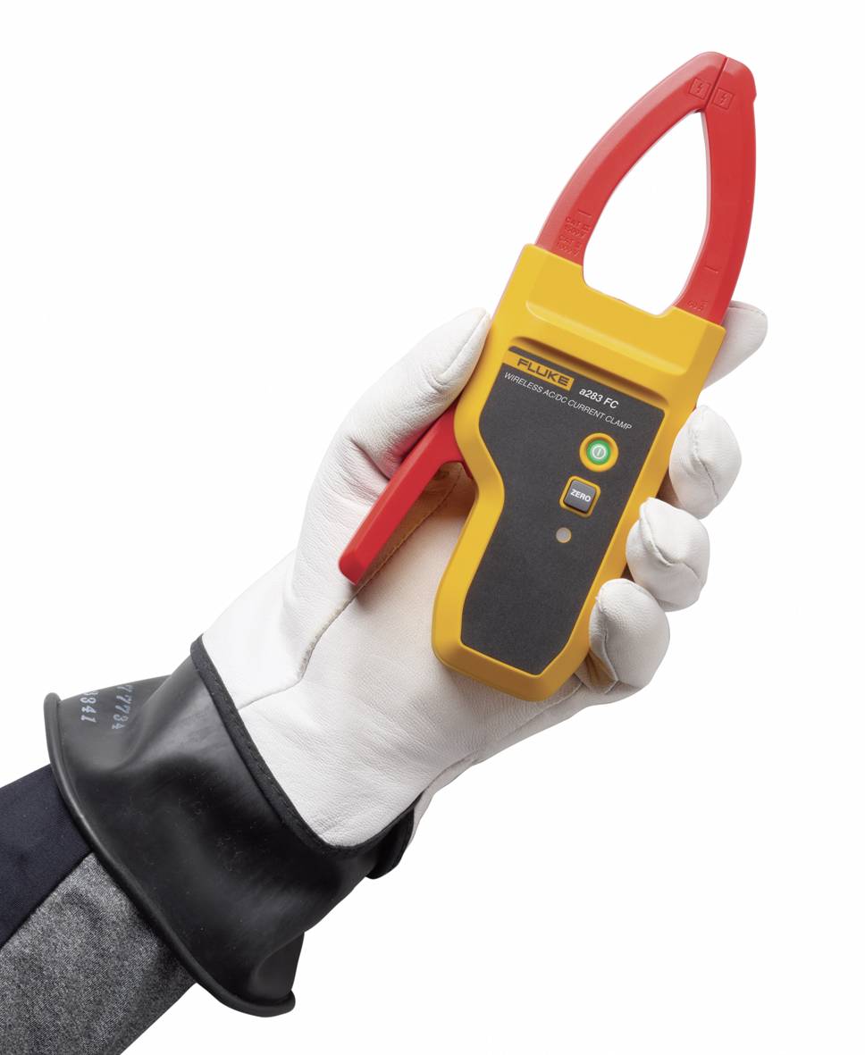 Dłoń w rękawicy ochronnej trzyma żółte cęgi elektryczne z czerwonymi zaciskami, wyświetlaczem cyfrowym i przyciskami sterującymi.