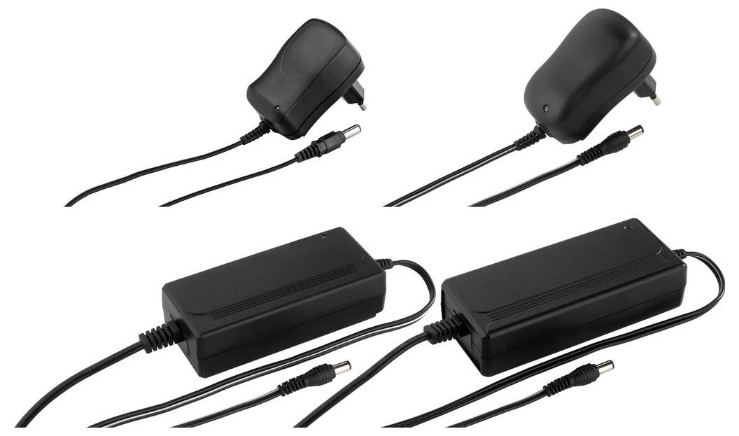 Cztery czarne zasilacze z wtyczkami, dwa na górze i dwa na dole. Różne rozmiary do urządzeń elektronicznych, podłączone kable.