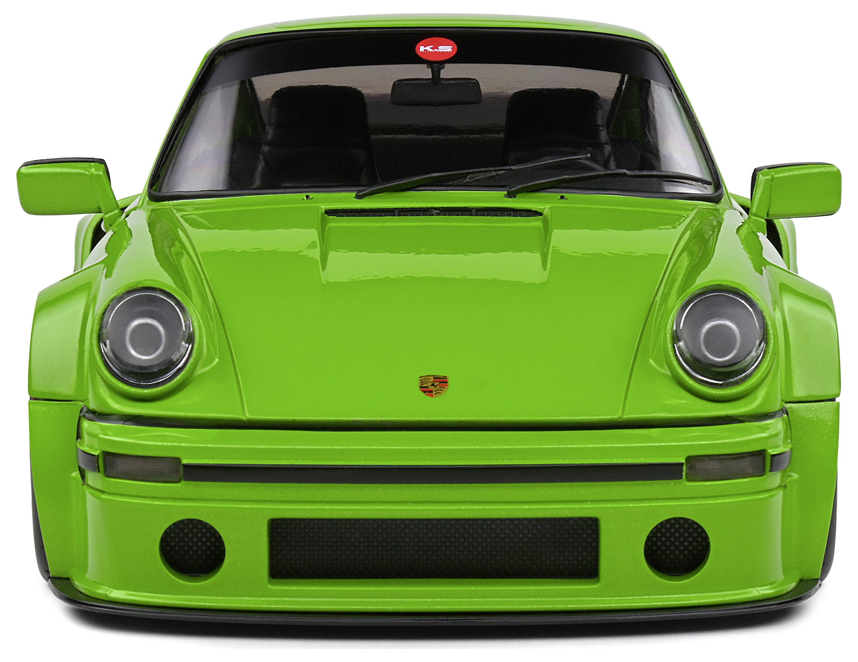 Zielony klasyczny sportowy samochód widziany od przodu, z okrągłymi reflektorami i charakterystycznym designem przedniej części nadwozia.