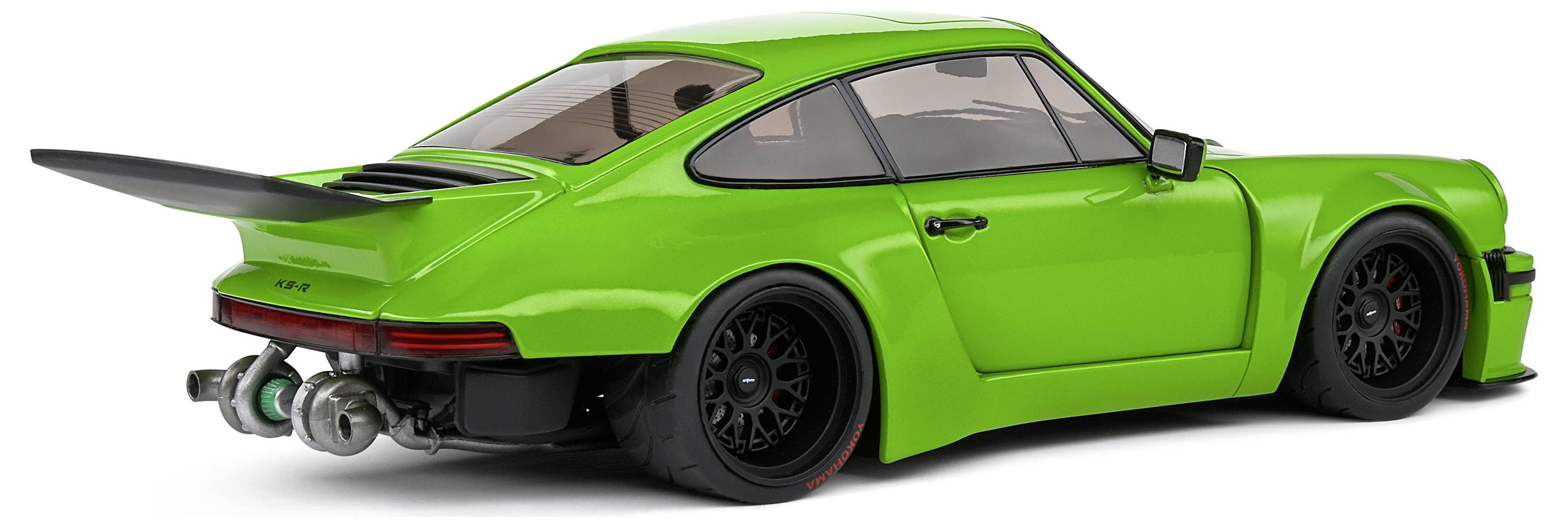 Zielony samochodzik zabawkowy w stylu sportowego auta z wyraźnym tylnym spoilerem i czarnymi kołami, sfotografowany z boku.