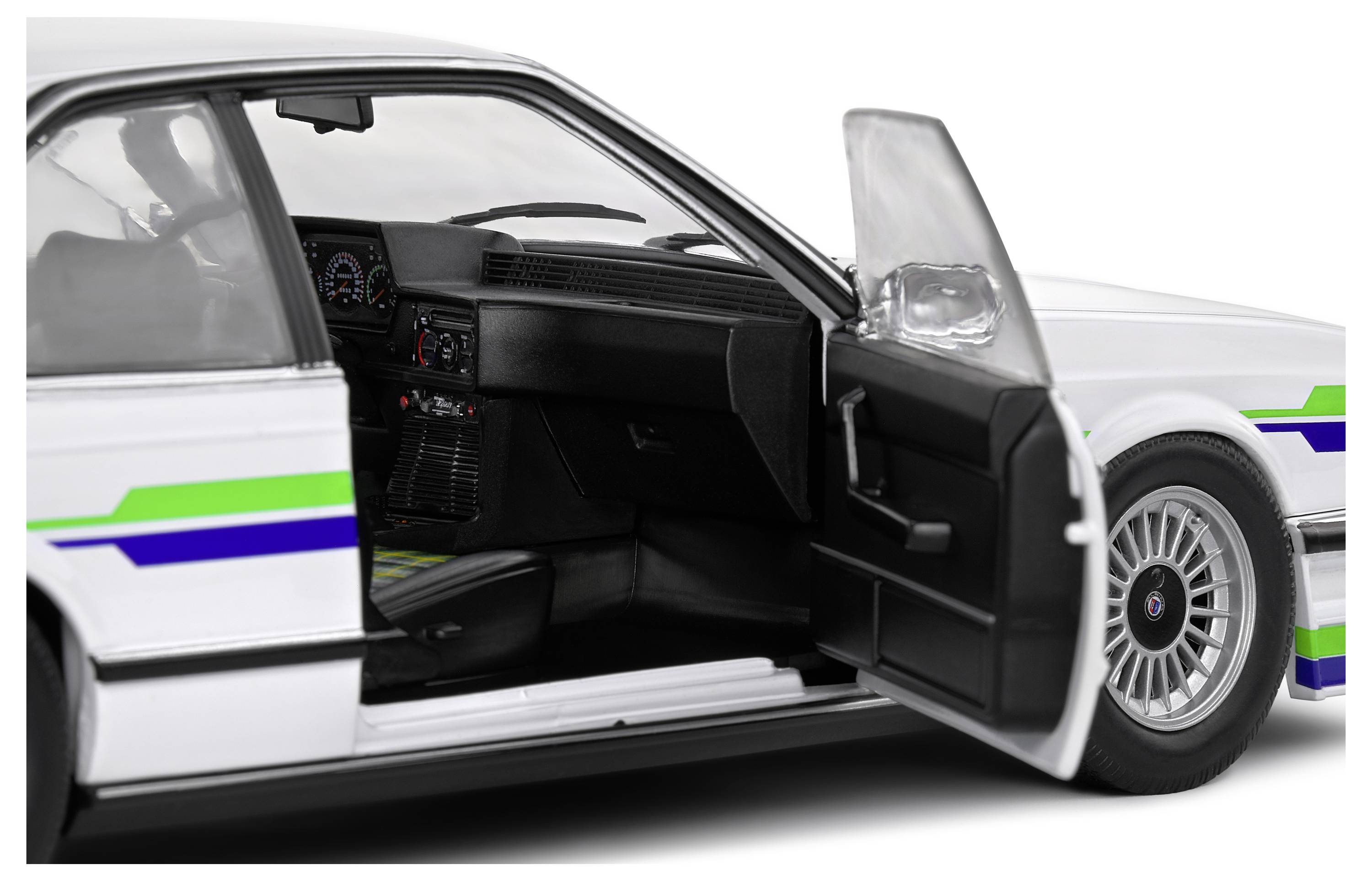 Białe auto z otwartymi drzwiami odsłania wnętrze. Na nadwoziu znajdują się zielone i niebieskie pasy.