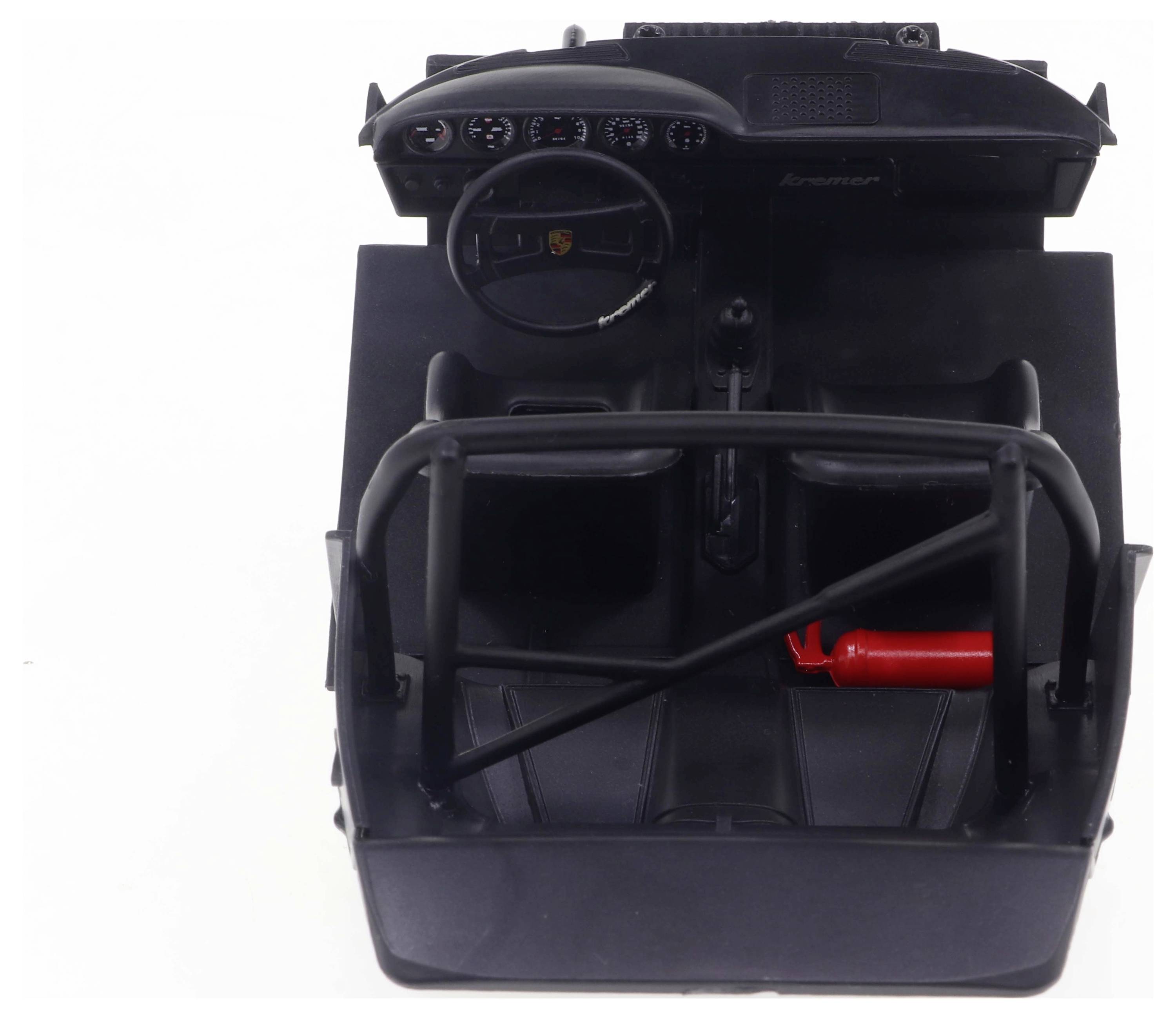 Model kokpitu samochodu z kierownicą, deską rozdzielczą, klatką bezpieczeństwa i gaśnicą na fotelu pasażera.